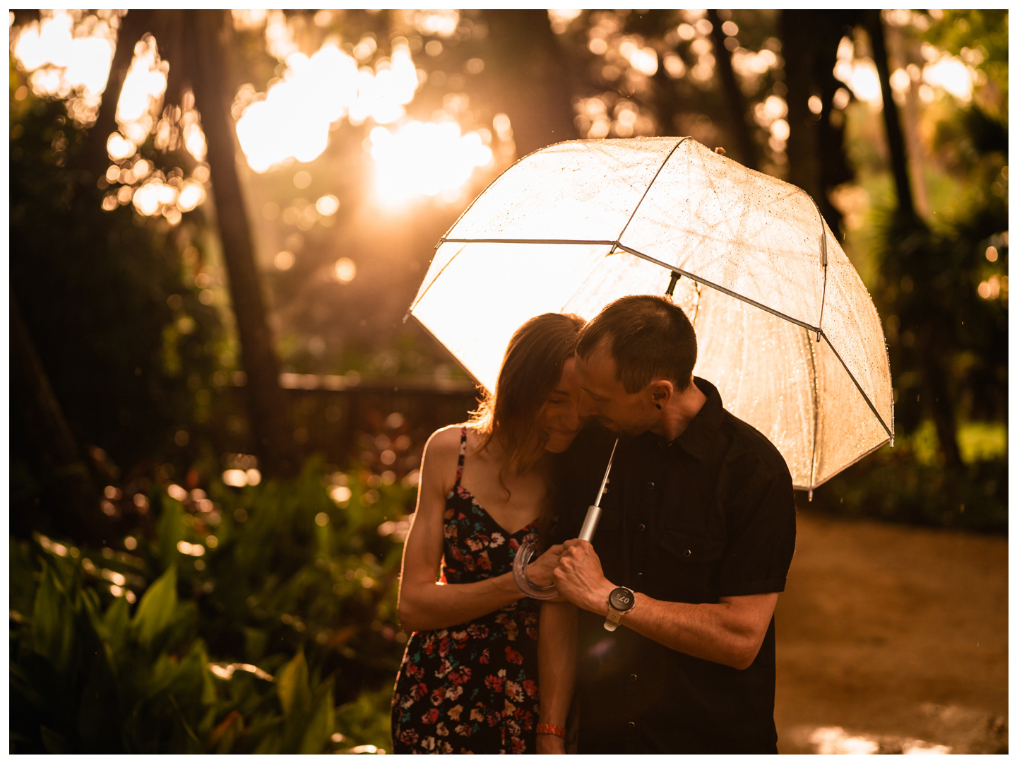 Couple sharing a quiet moment beneath a backlit umbrella at Washington Oaks Gardens.