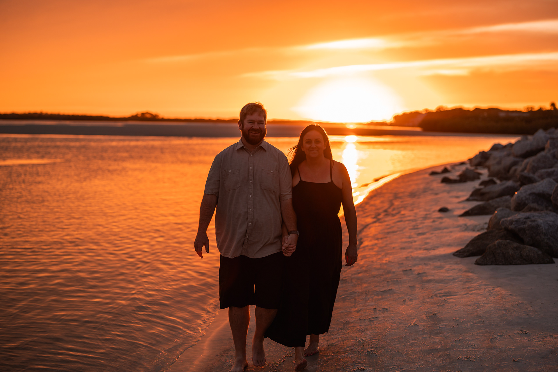 Couple walking along Ponce Inlet Beach during a family sunset photography session.