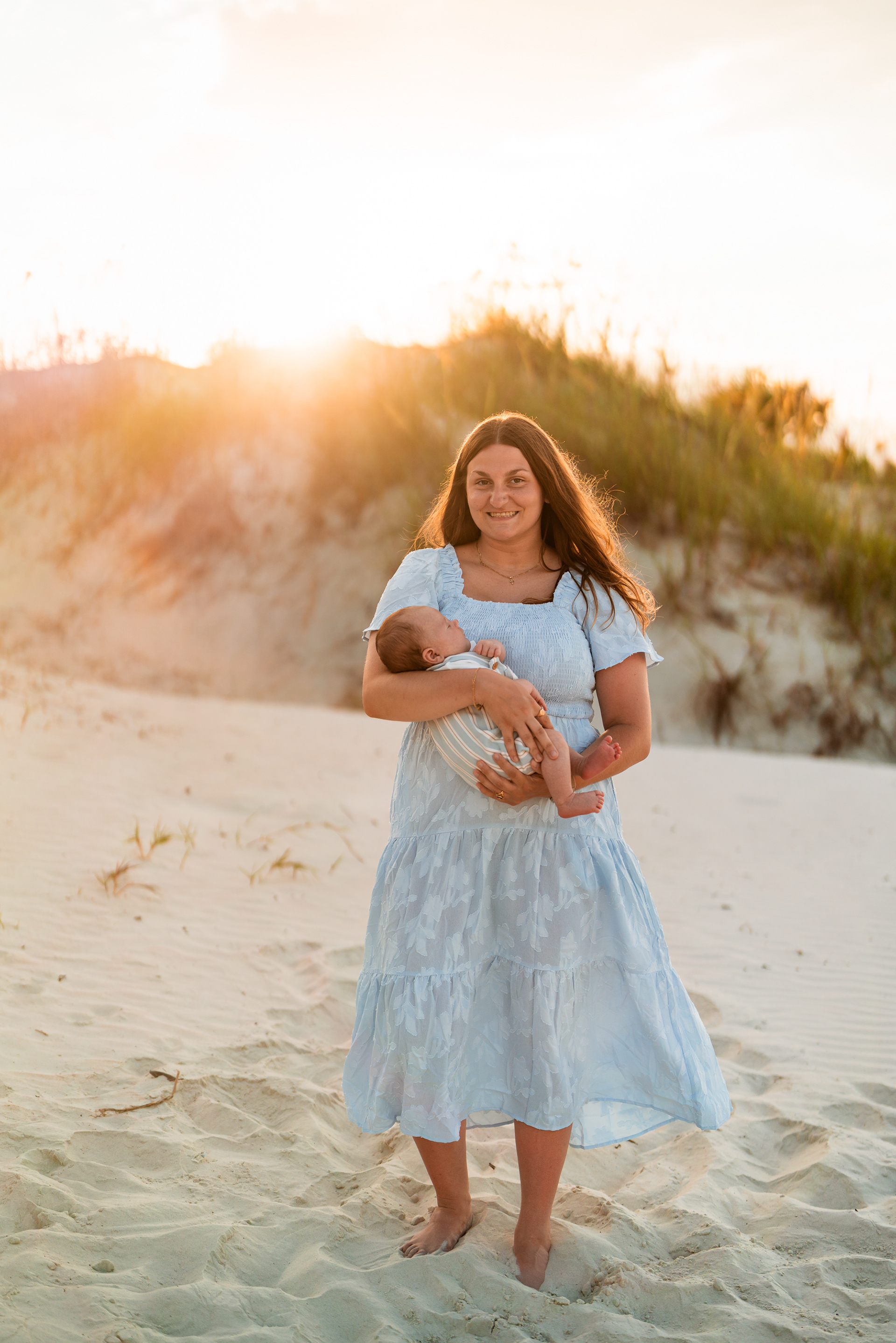 Mother holding her baby with sunset light in the dunes at Ponce Inlet Jetty Beach.