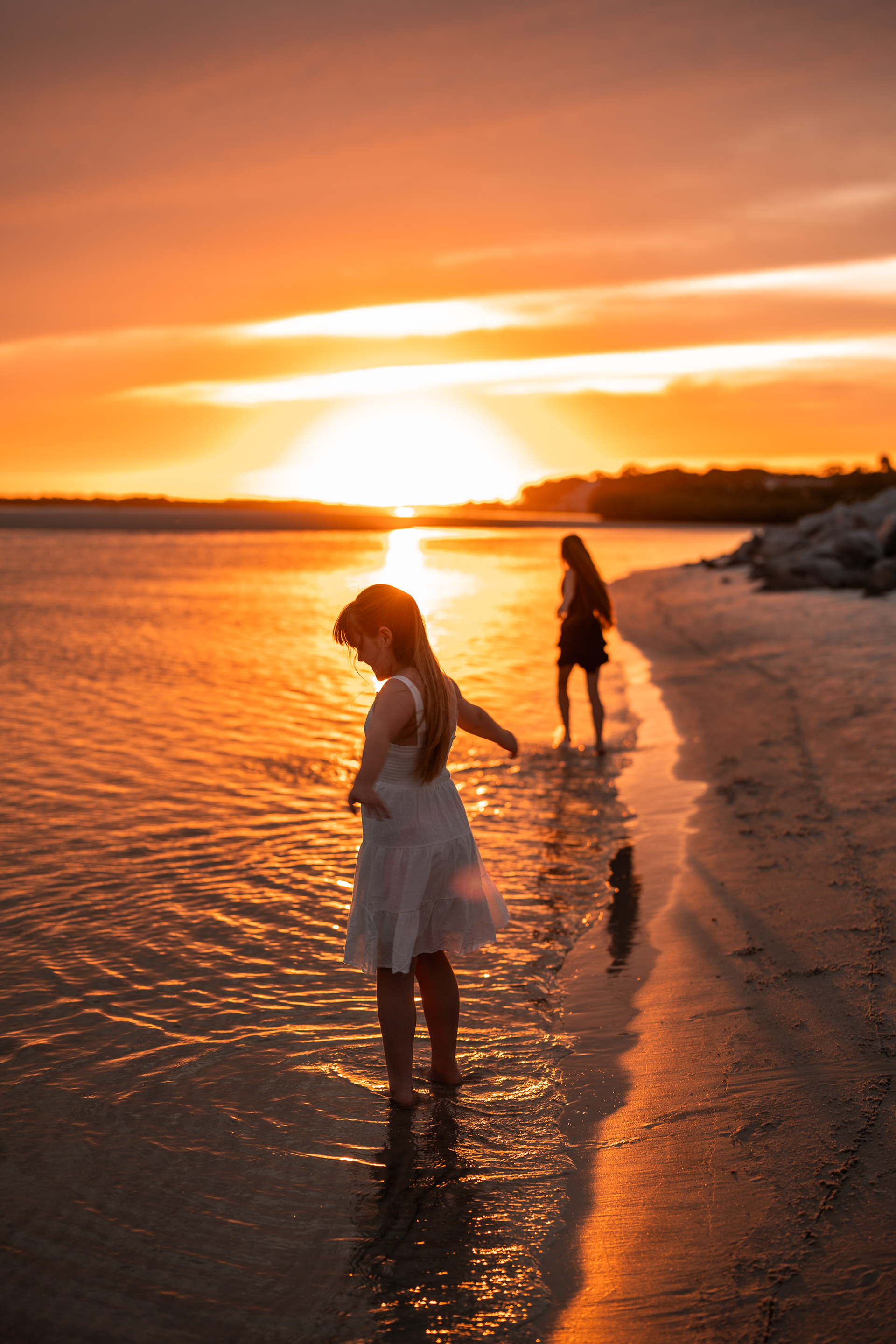 Girl looking down at the shoreline during a sunset photo session at Ponce Inlet Beach.