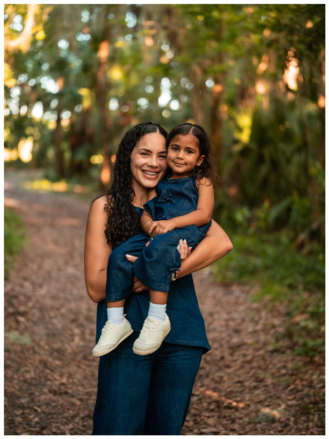 Mother and daughter sitting together on a nature path at Buschman Park