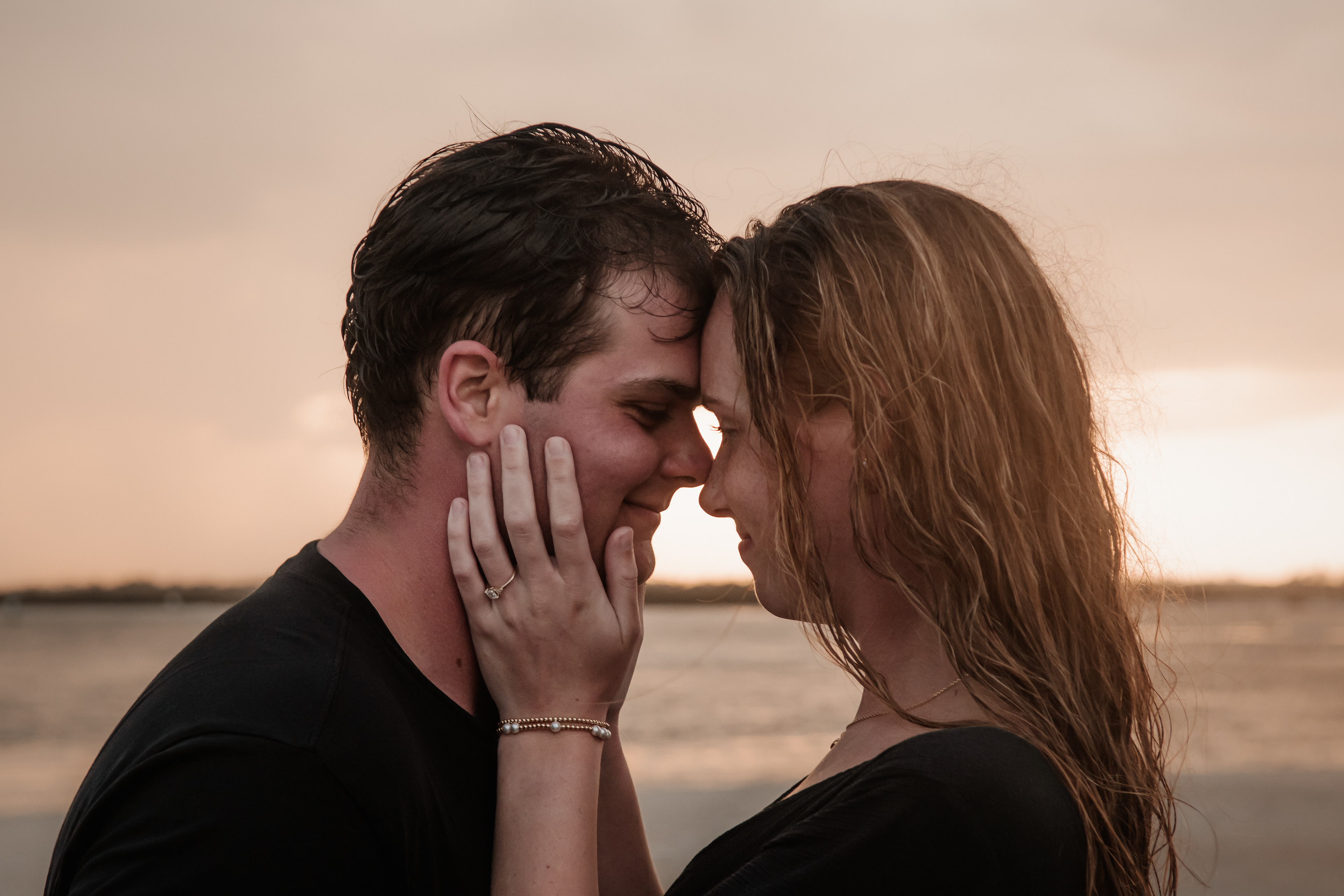 Romantic Ponce Inlet engagement photo of couple touching foreheads at sunset