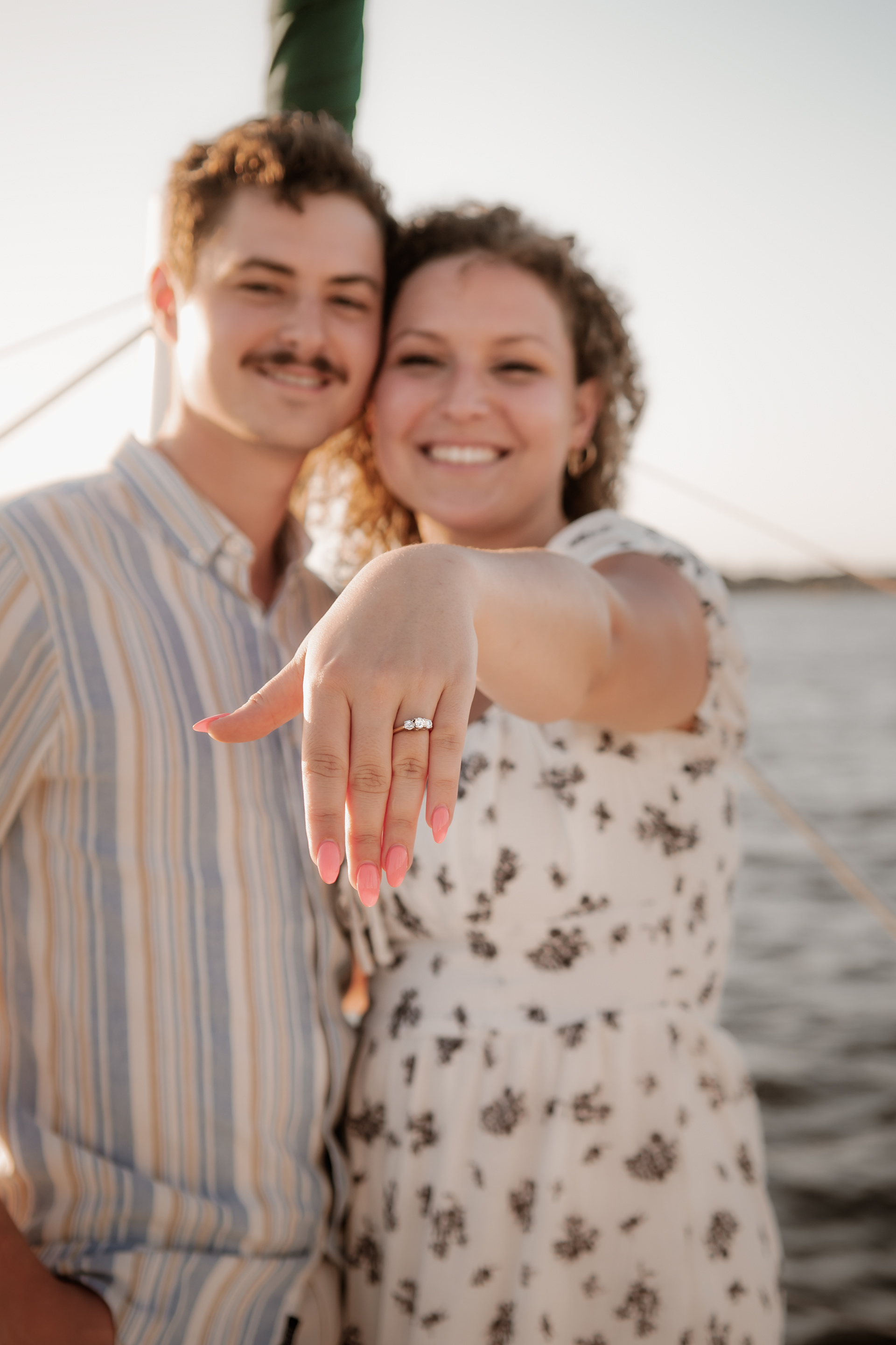 Bride-to-be showing engagement ring during sailboat engagement photos in Daytona Beach Florida