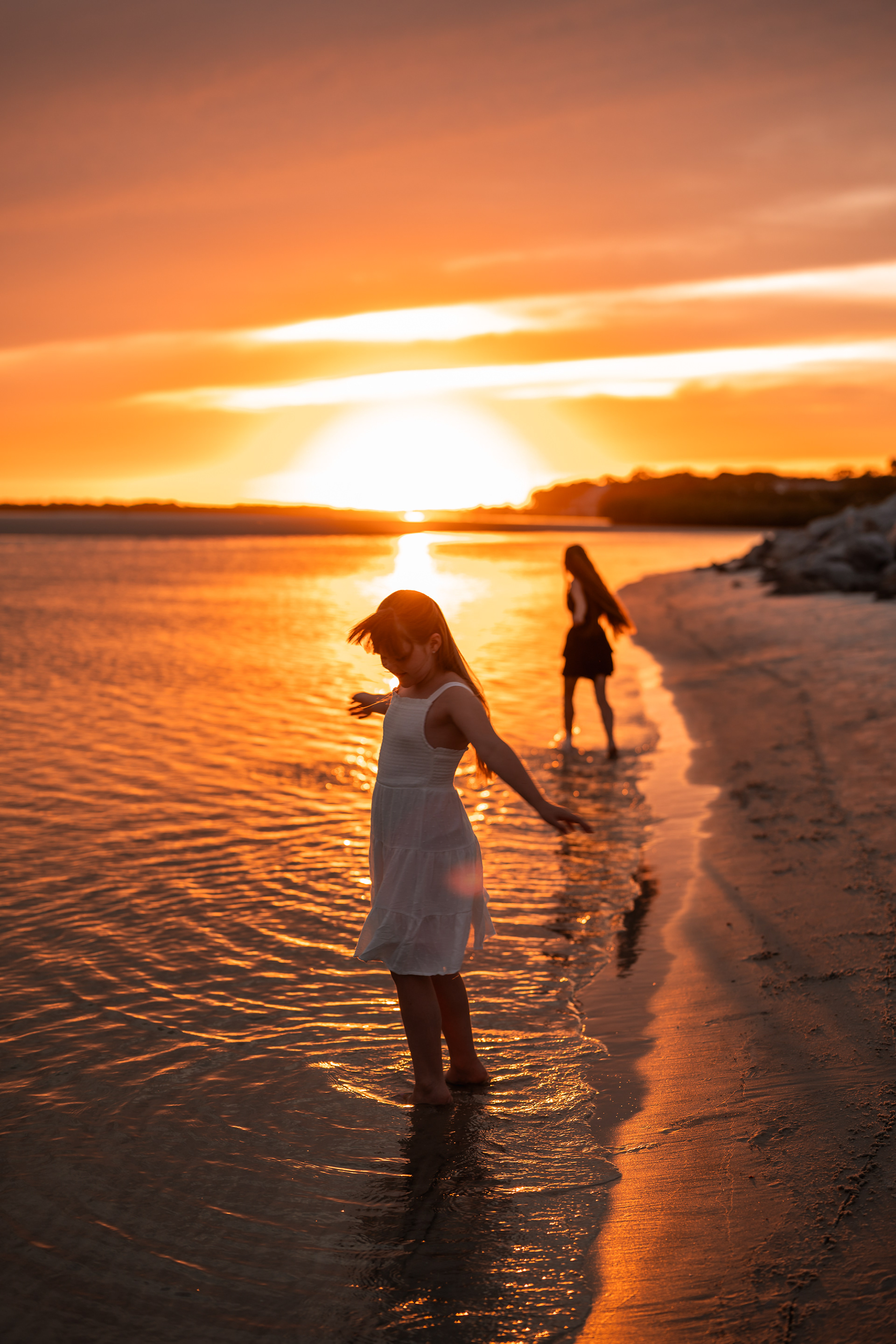 Girl standing by the shoreline during a sunset beach photography session in Ponce Inlet, Florida.