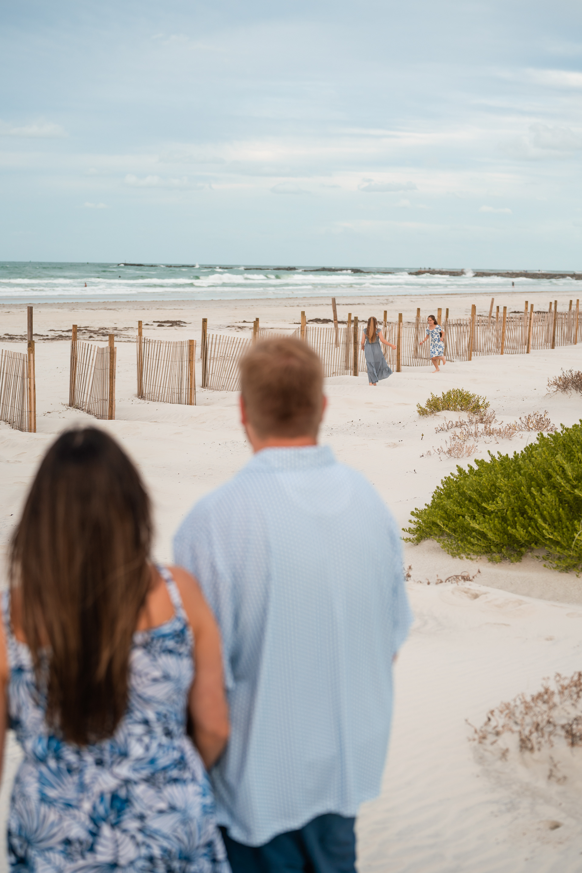 Family walking through the dunes during a beach photo session in Ponce Inlet, Florida.
