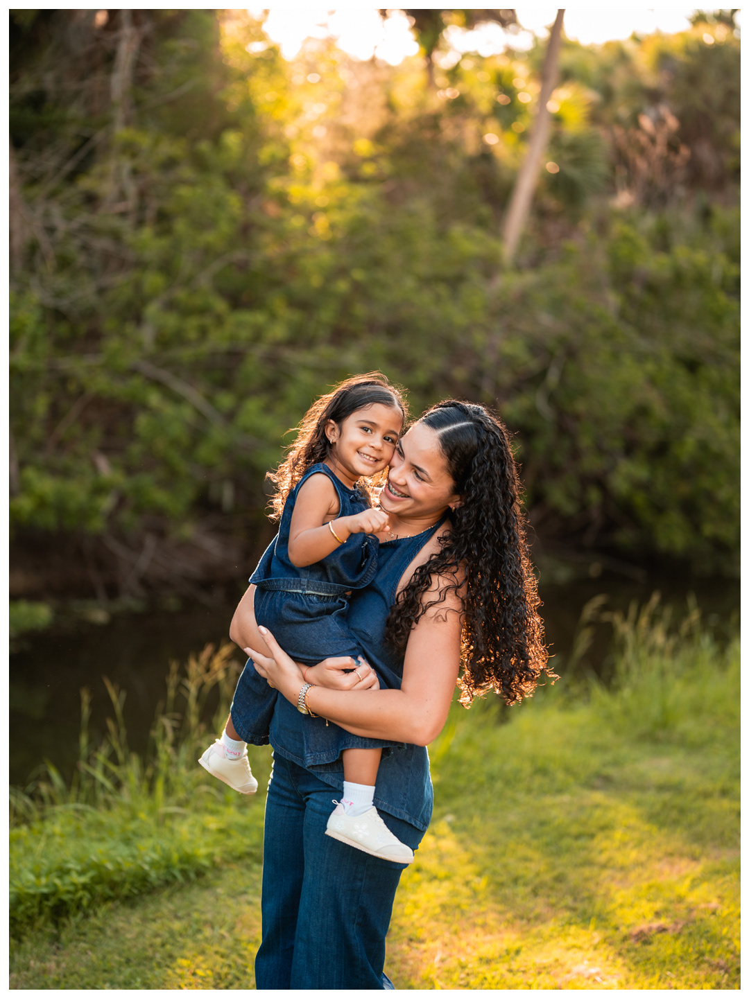 Mother holding daughter near the water during Buschman Park family photos