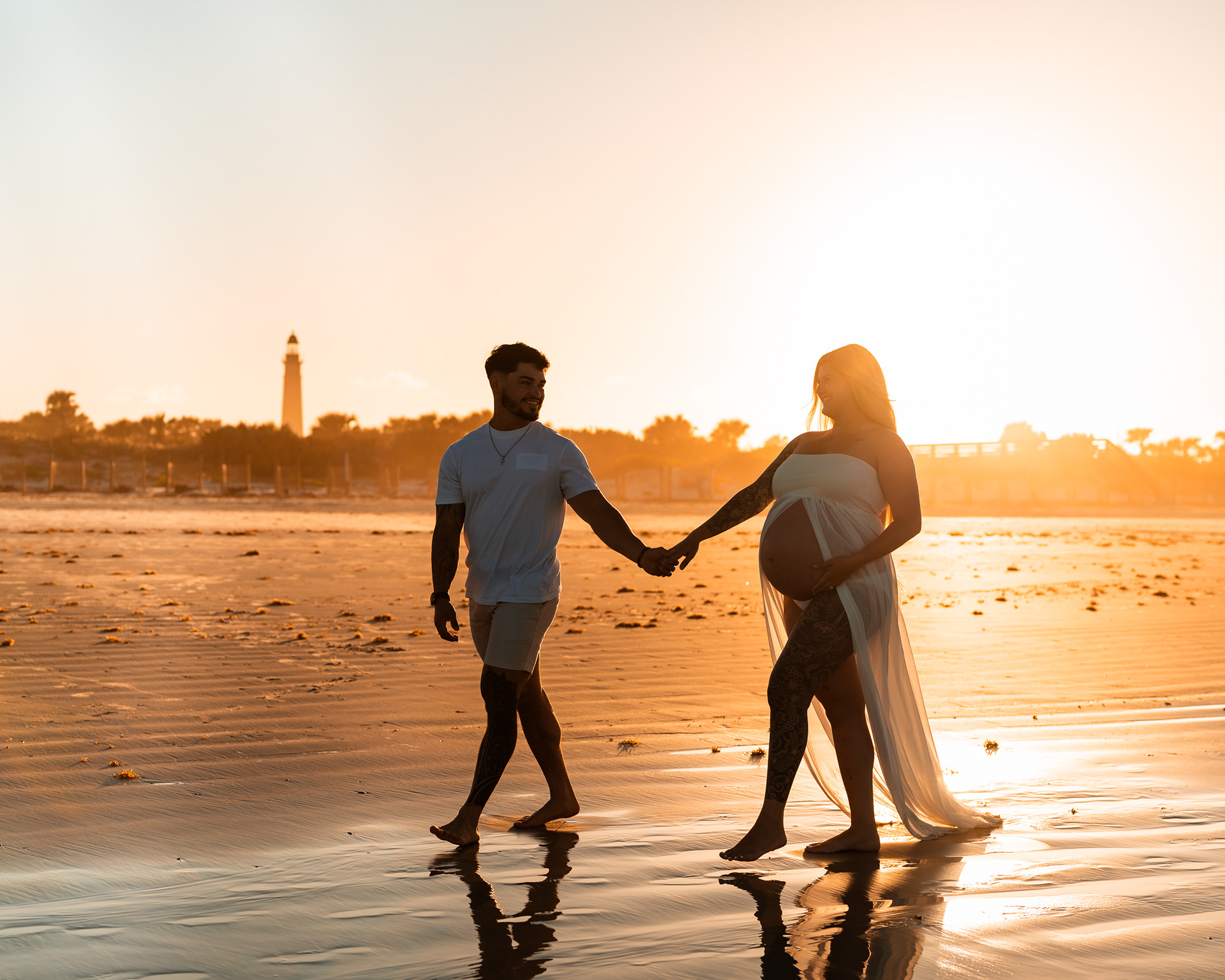 Maternity couple photo holding hands by the water during a Florida beach session