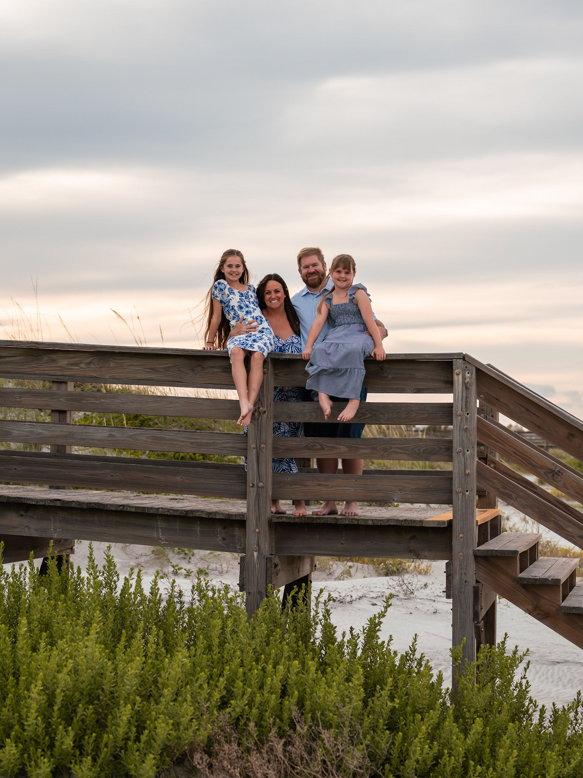 Family portrait on the boardwalk near the dunes during a Ponce Inlet Beach photography session.