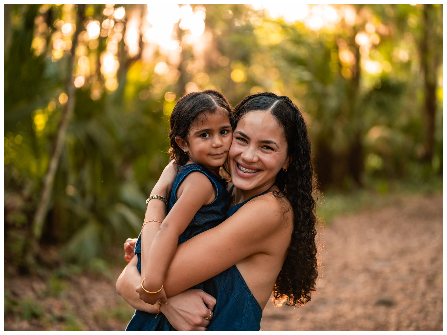 Mother holding daughter on wooded path at Buschman Park in Port Orange