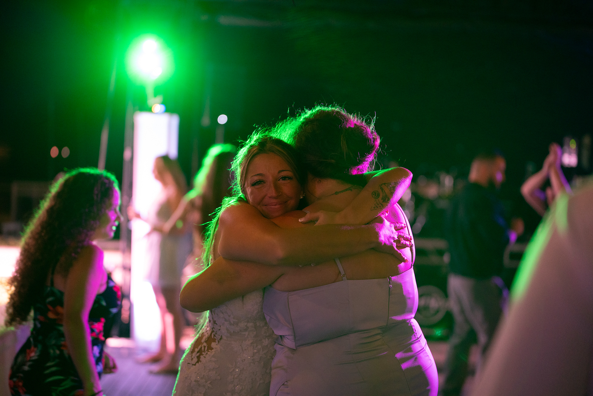 Bride hugging a guest on the dance floor at her Daytona Beach wedding reception.