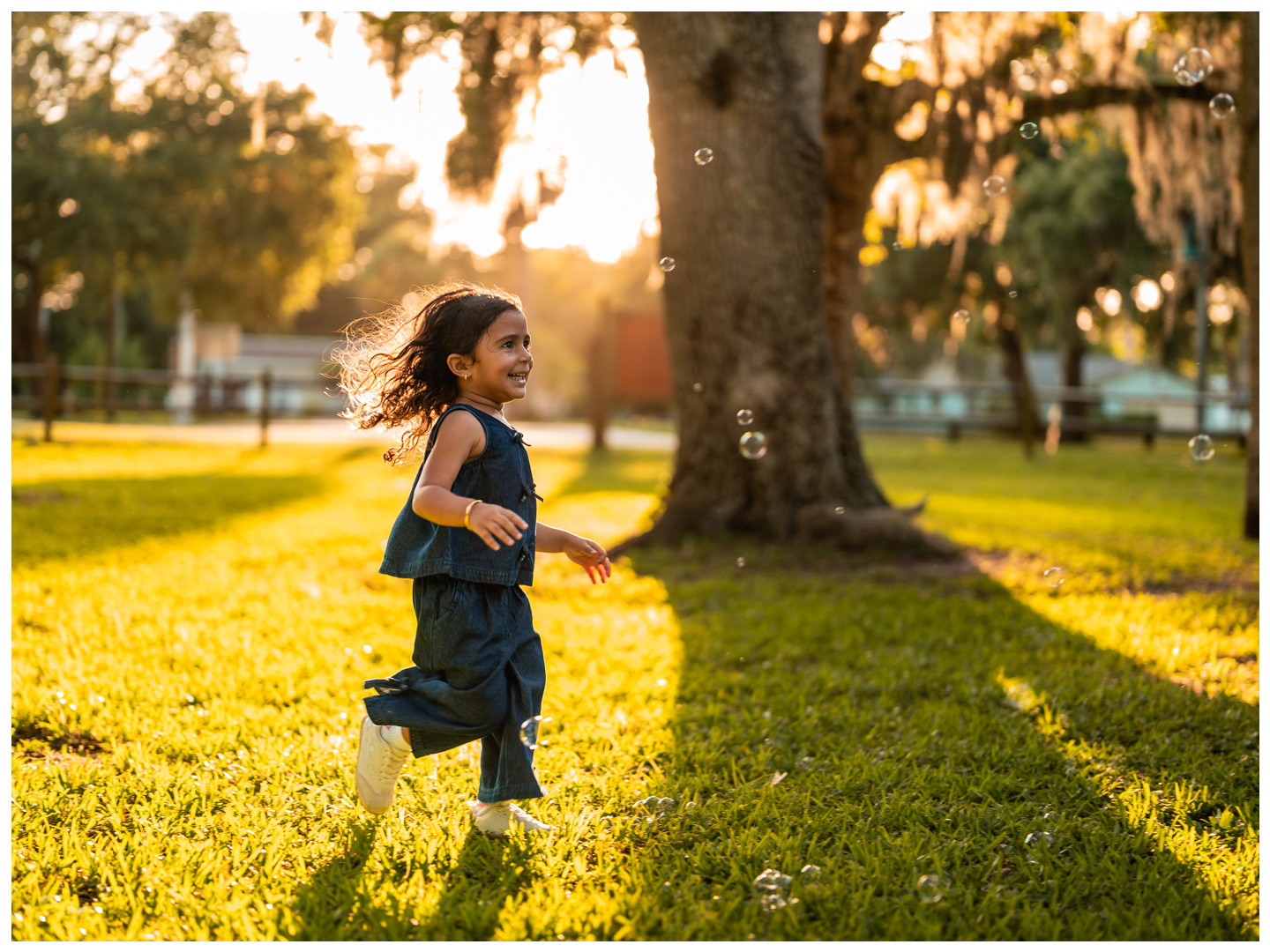 Girl running through golden light during family photos at Buschman Park