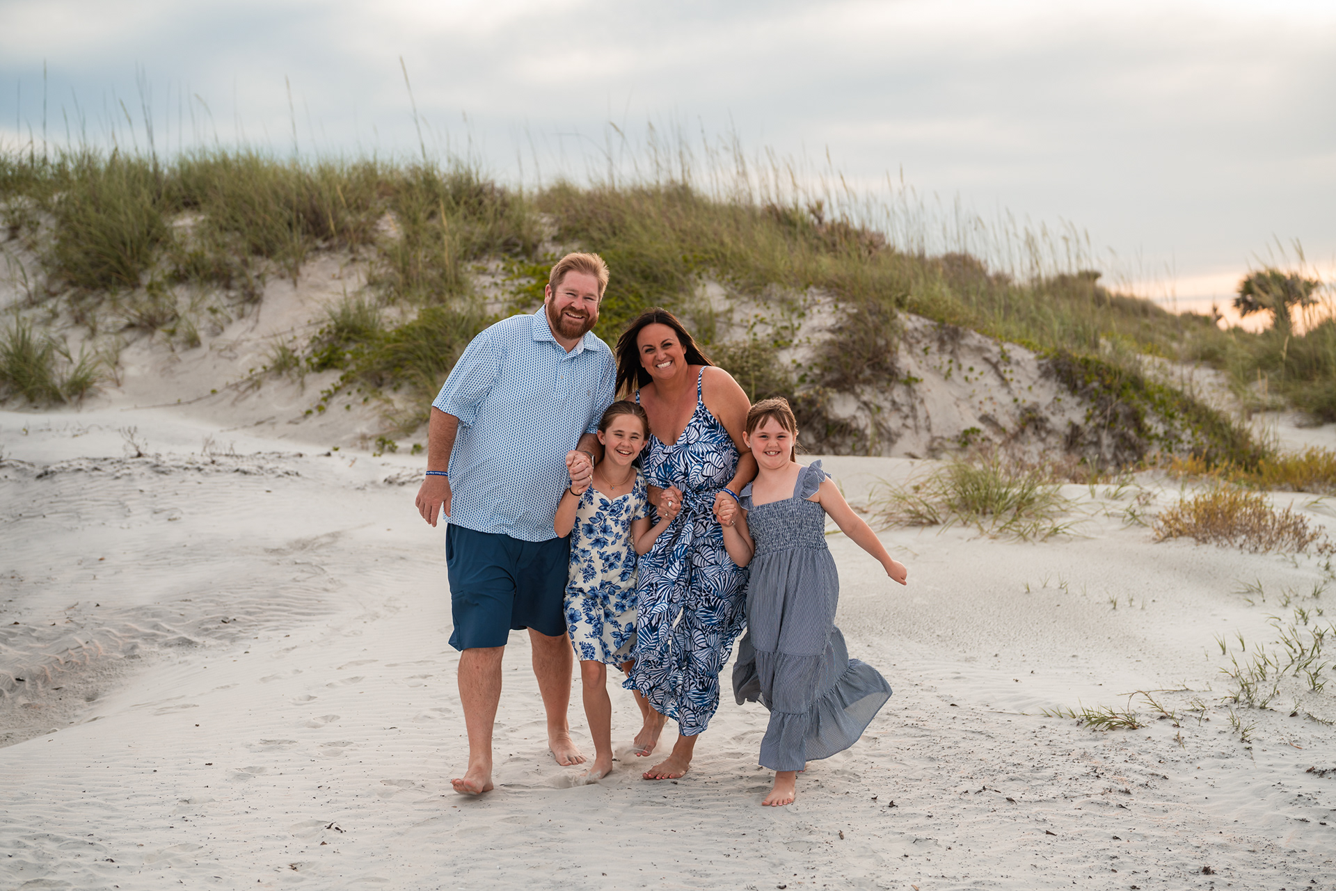 Family walking together near the dunes during a Ponce Inlet Beach photography session.