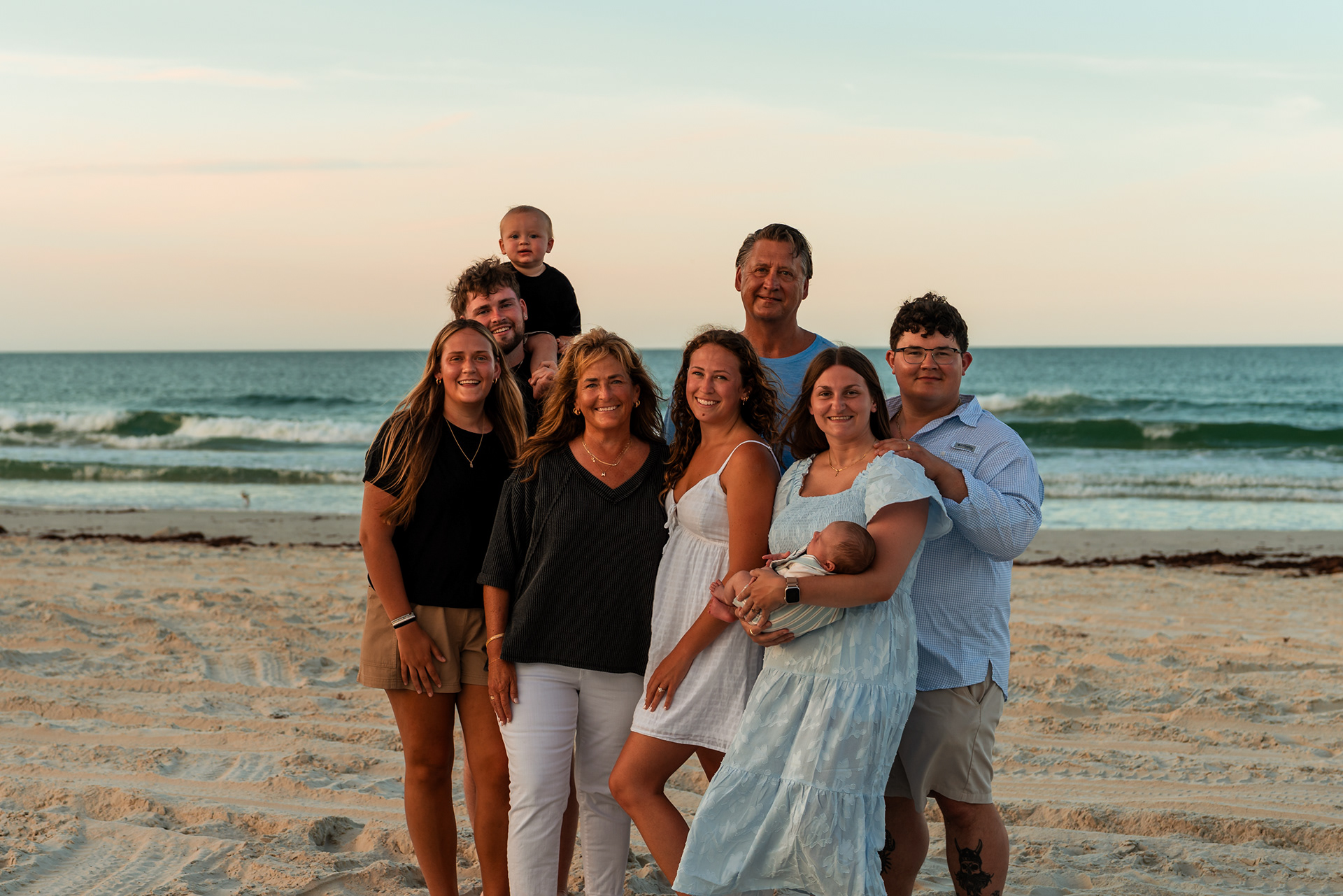 Extended family standing together by the ocean during a Ponce Inlet Jetty Beach photography session.