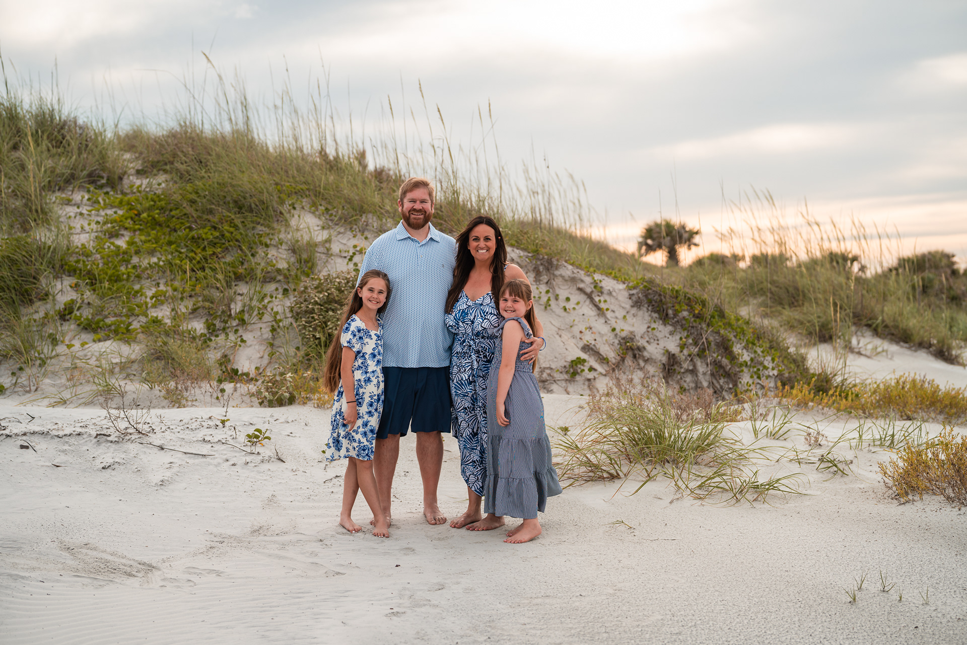 Family standing together in the beach dunes during a Ponce Inlet family photo session.