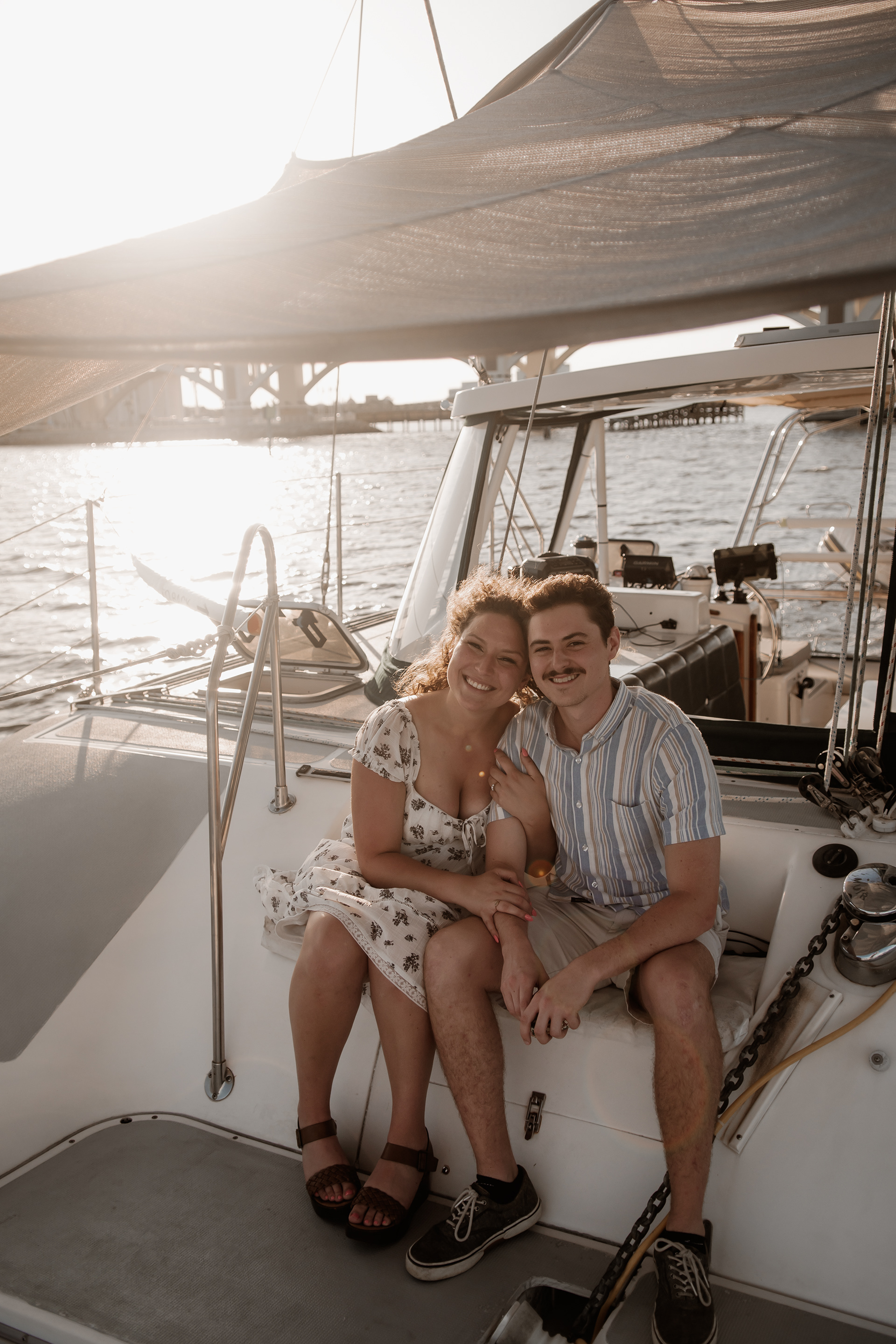 Couple sitting together under sailboat canopy during Daytona Beach engagement session