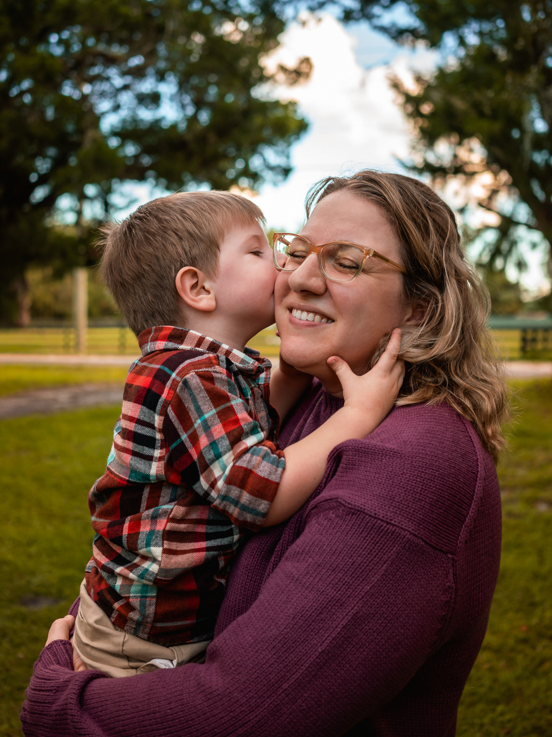 Sweet moment of mother and son hugging and laughing together outdoors in New Smyrna Beach, Florida.