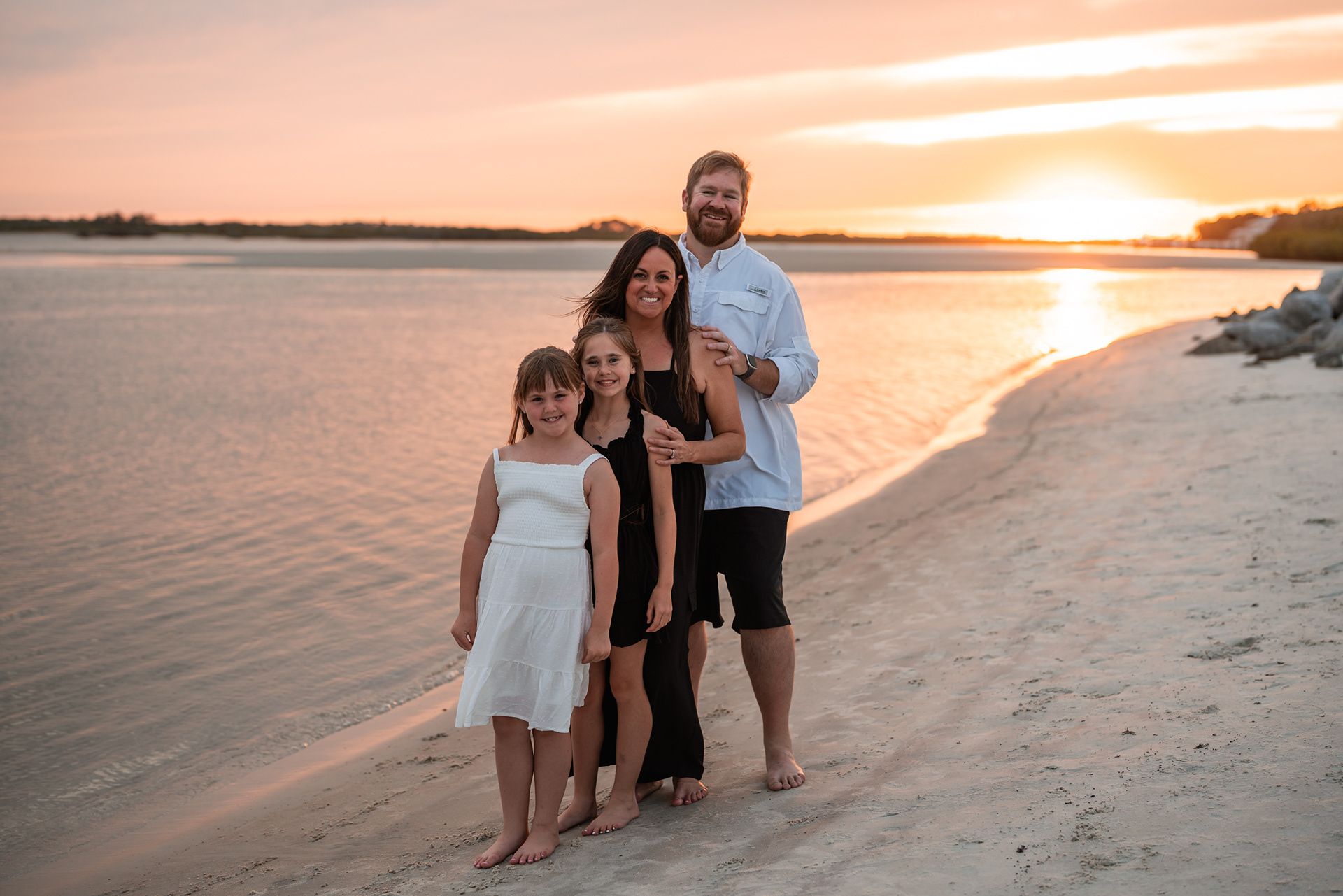 Couple sitting together in the sand during a sunset beach photography session at Ponce Inlet.