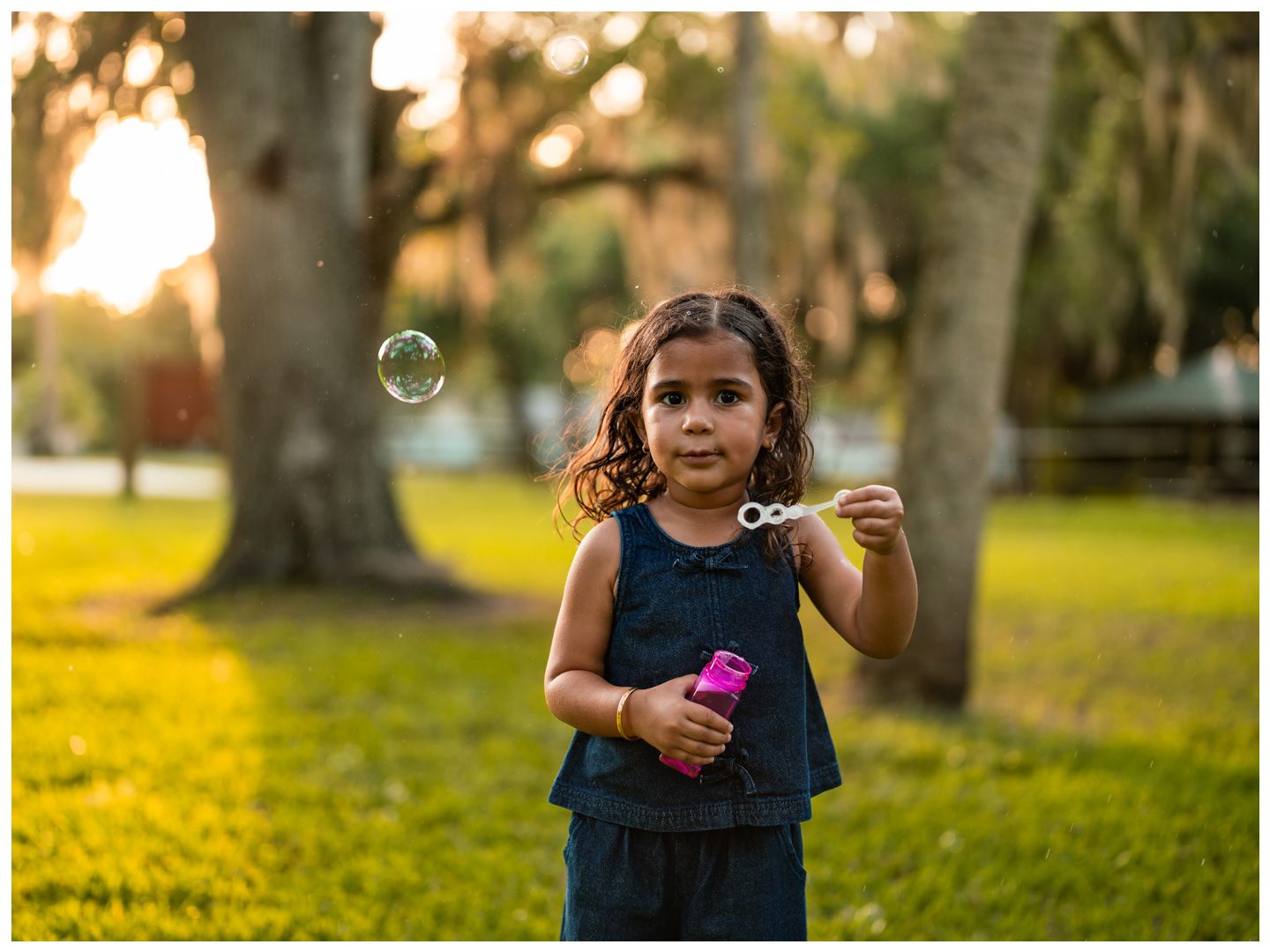 Child blowing bubbles during mother and daughter photos at Buschman Park