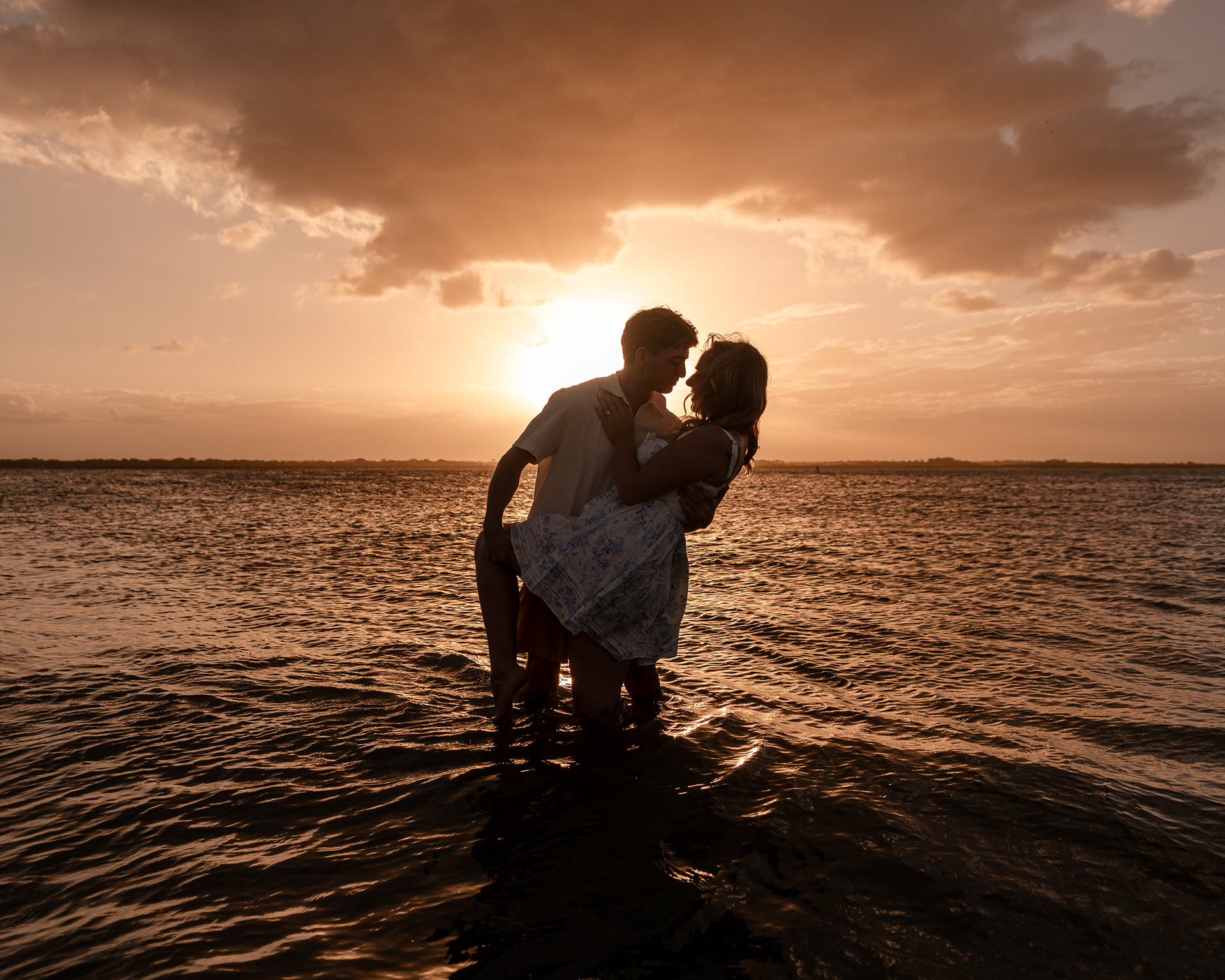 New Smyrna Beach engagement portraits at sunset, Joey and Lexi sharing a quiet moment by the water.