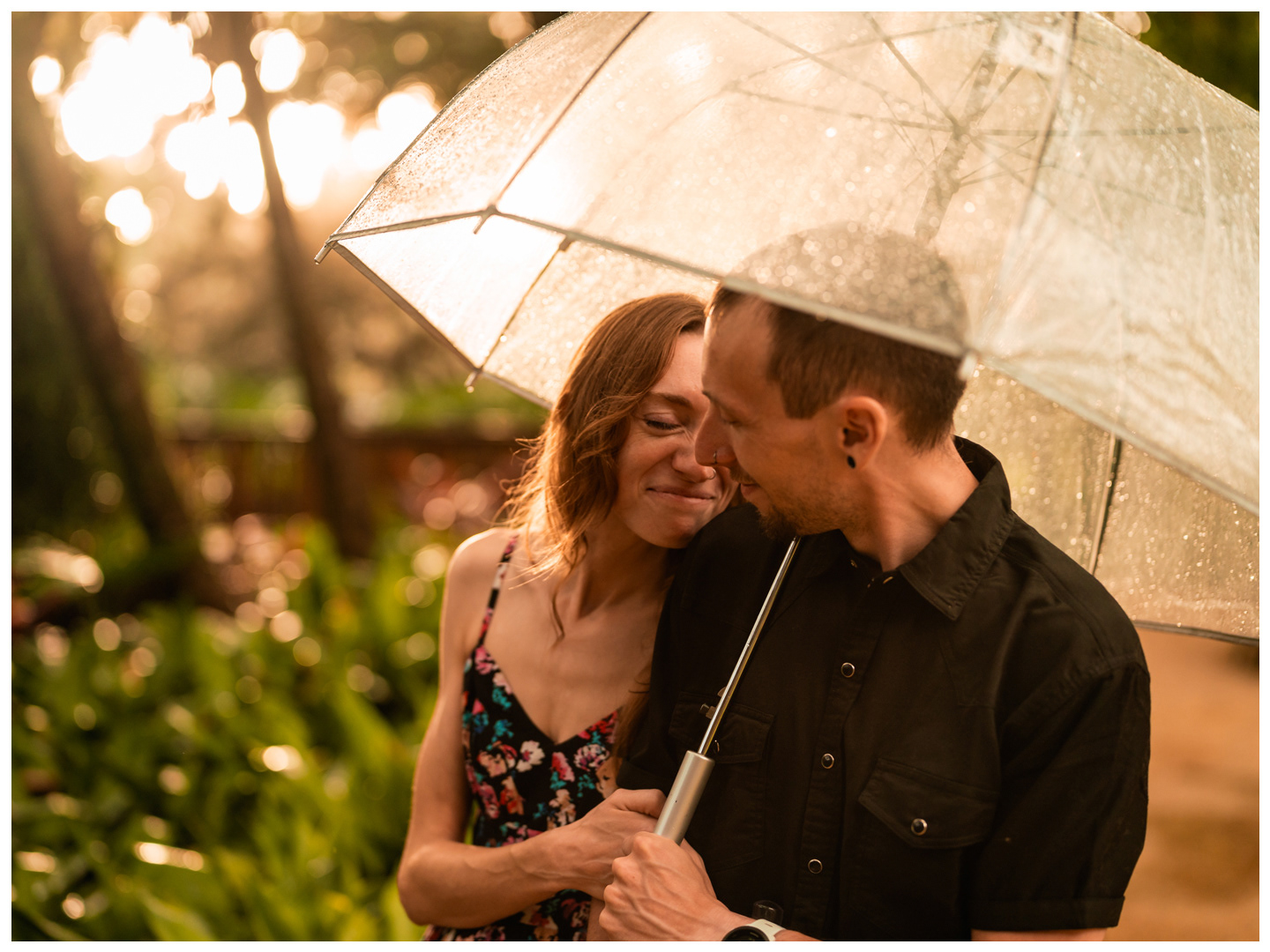 Couple laughing together in a close portrait beneath an umbrella at Washington Oaks Gardens State Park.
