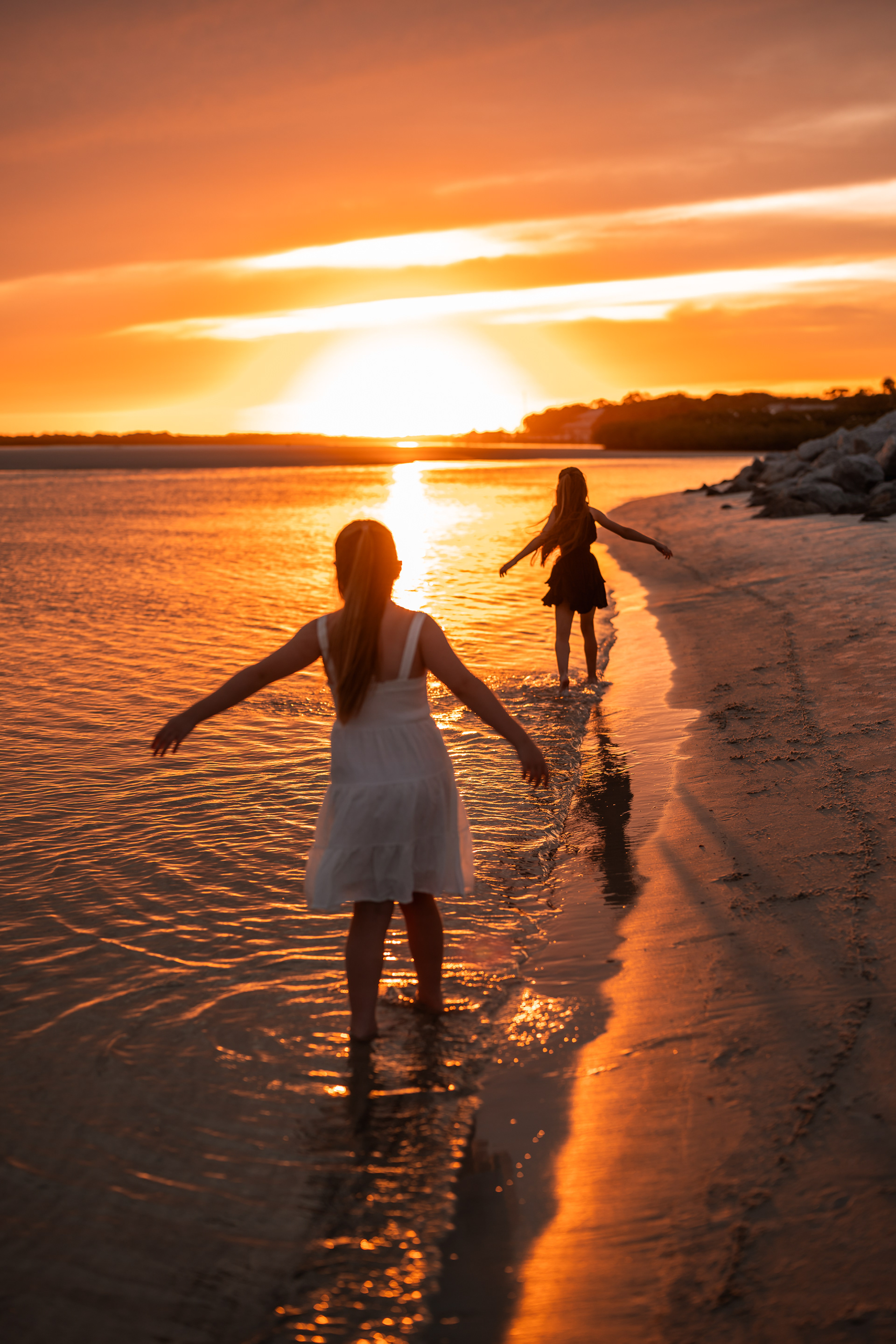 Child standing in shallow water during a sunset beach family photography session in Ponce Inlet.