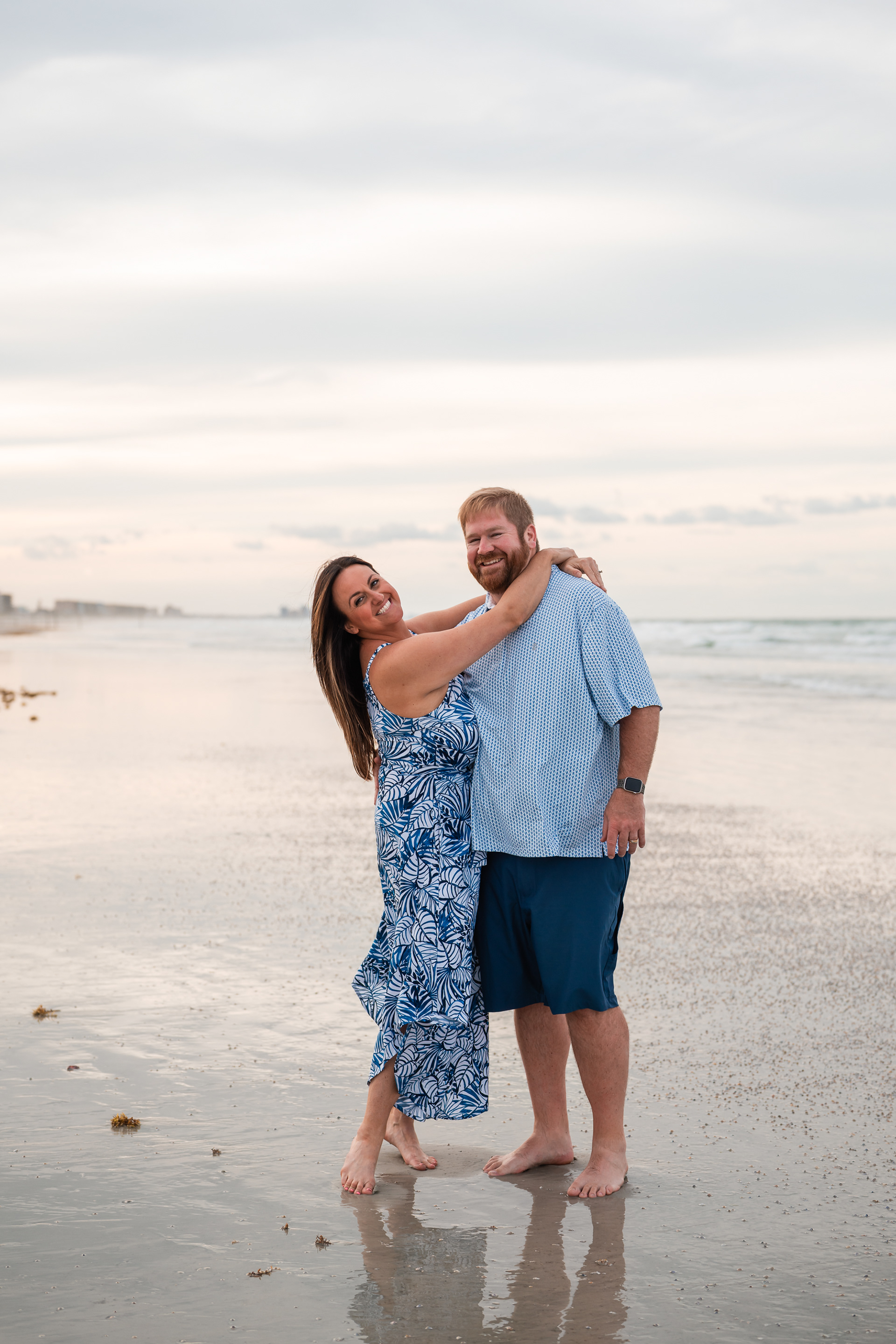 Couple laughing together on the beach during a family photography session in Ponce Inlet.