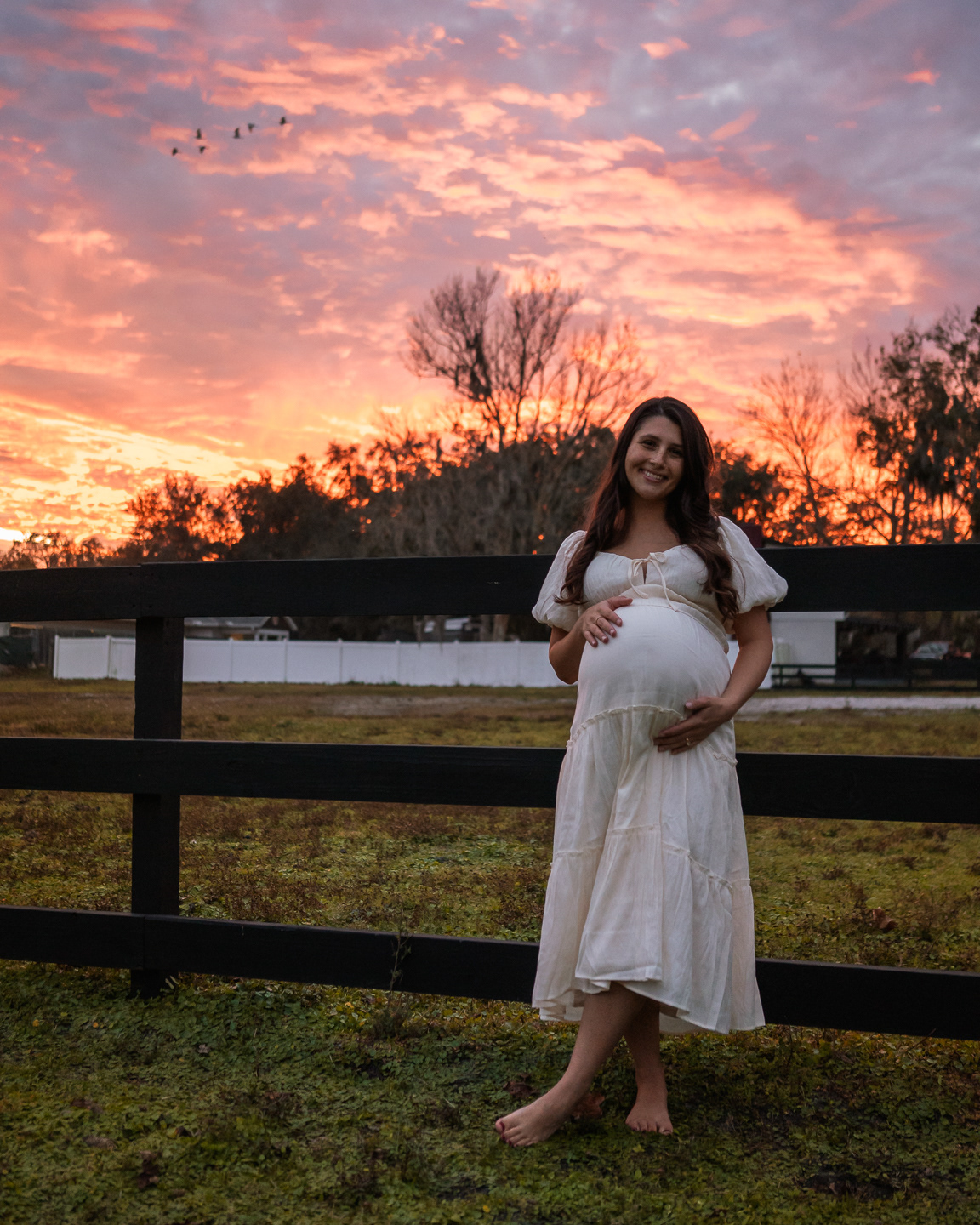 Pregnant mother in white dress during sunset maternity portraits in Florida