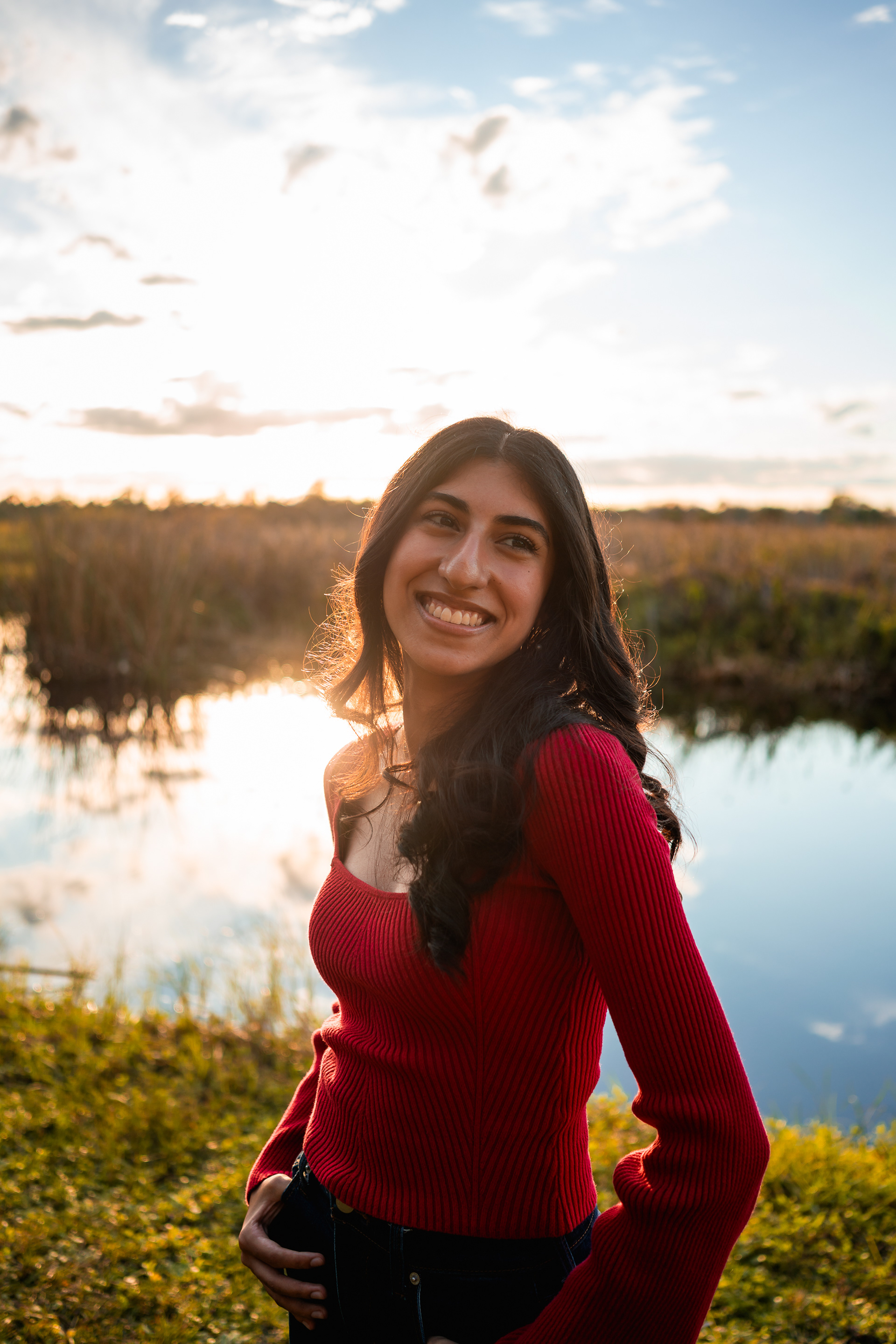 Ahaana smiling by the water for Lake Woodruff senior portraits in Volusia County