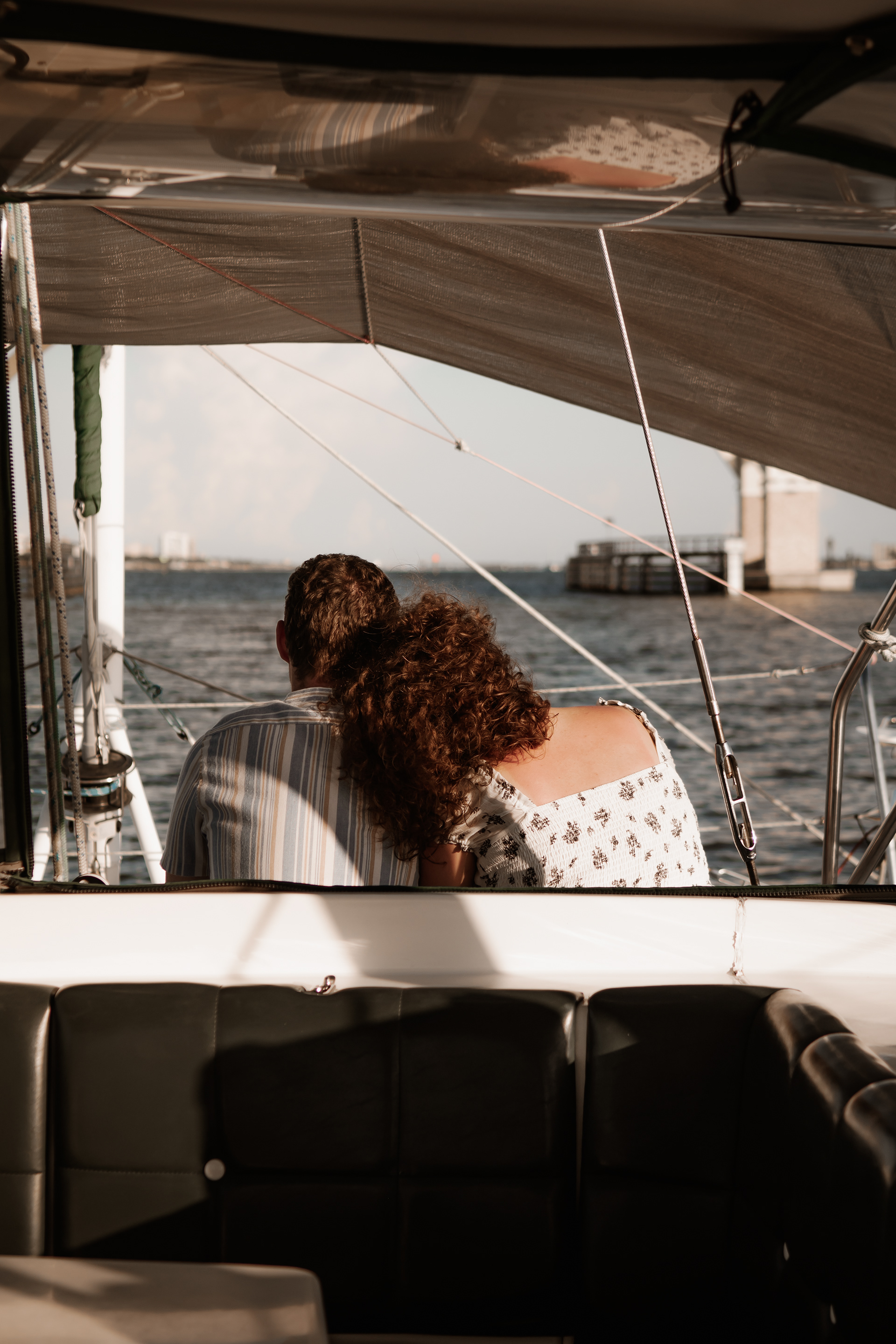 Candid sailboat engagement photo of couple looking out over the water in Daytona Beach