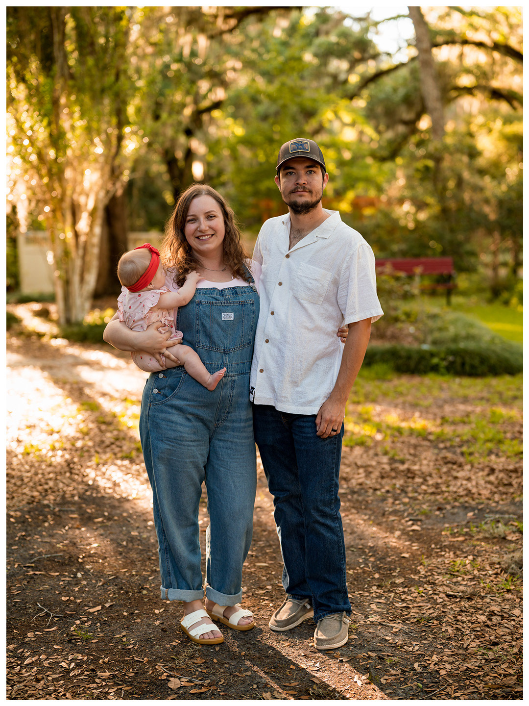 Outdoor family portrait at Dunlawton Sugar Mill Gardens in Port Orange with parents and baby