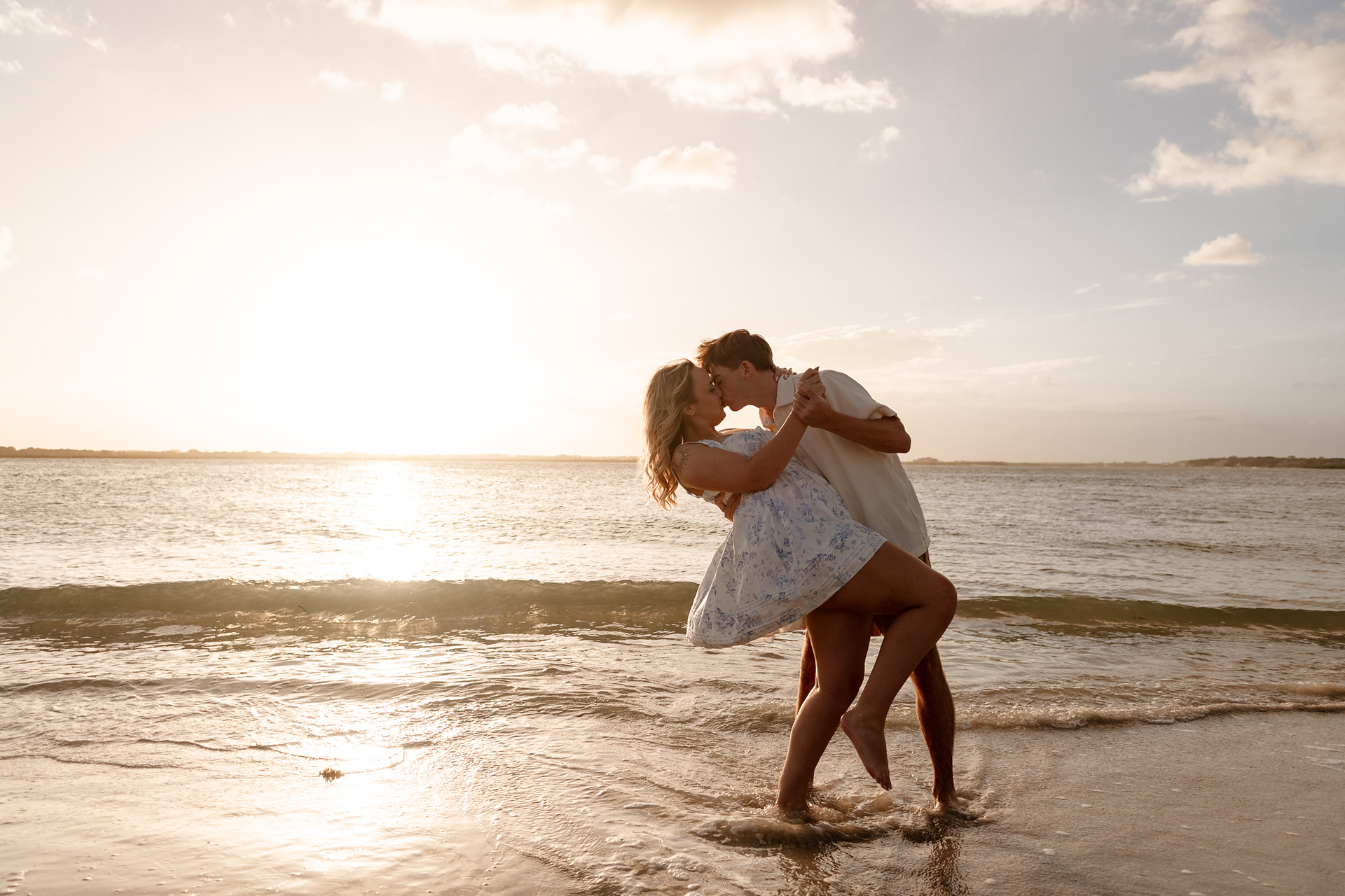 Beautiful engagement photograph new smyrna beach sunset couple kissing and dip