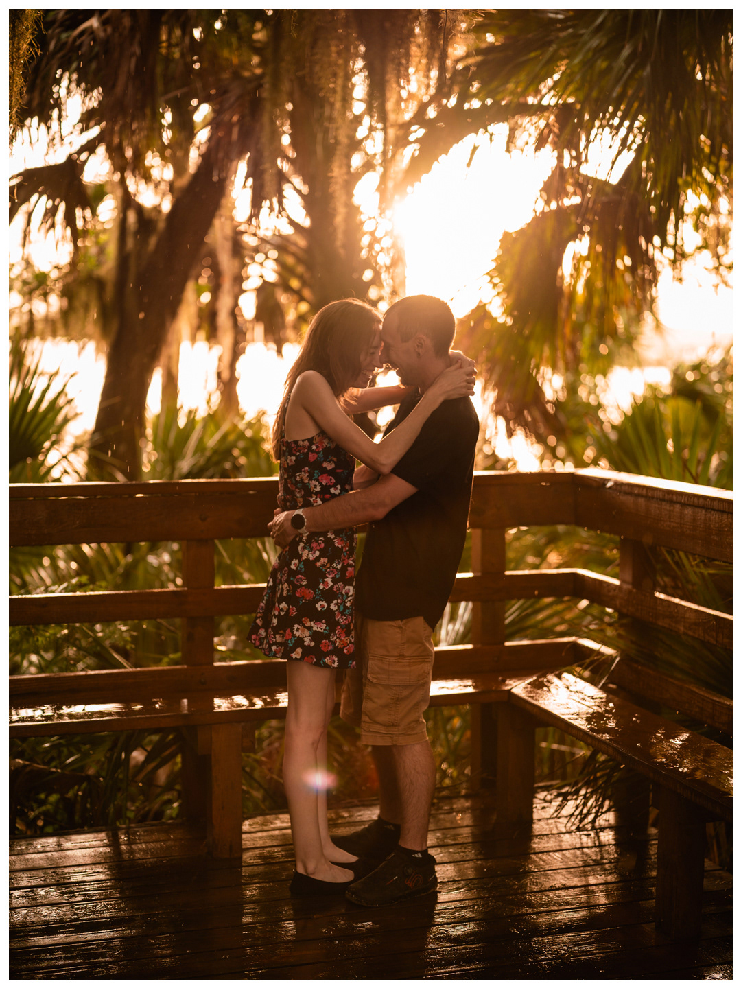 Couple kissing and embracing on a wet footbridge at Washington Oaks Gardens.