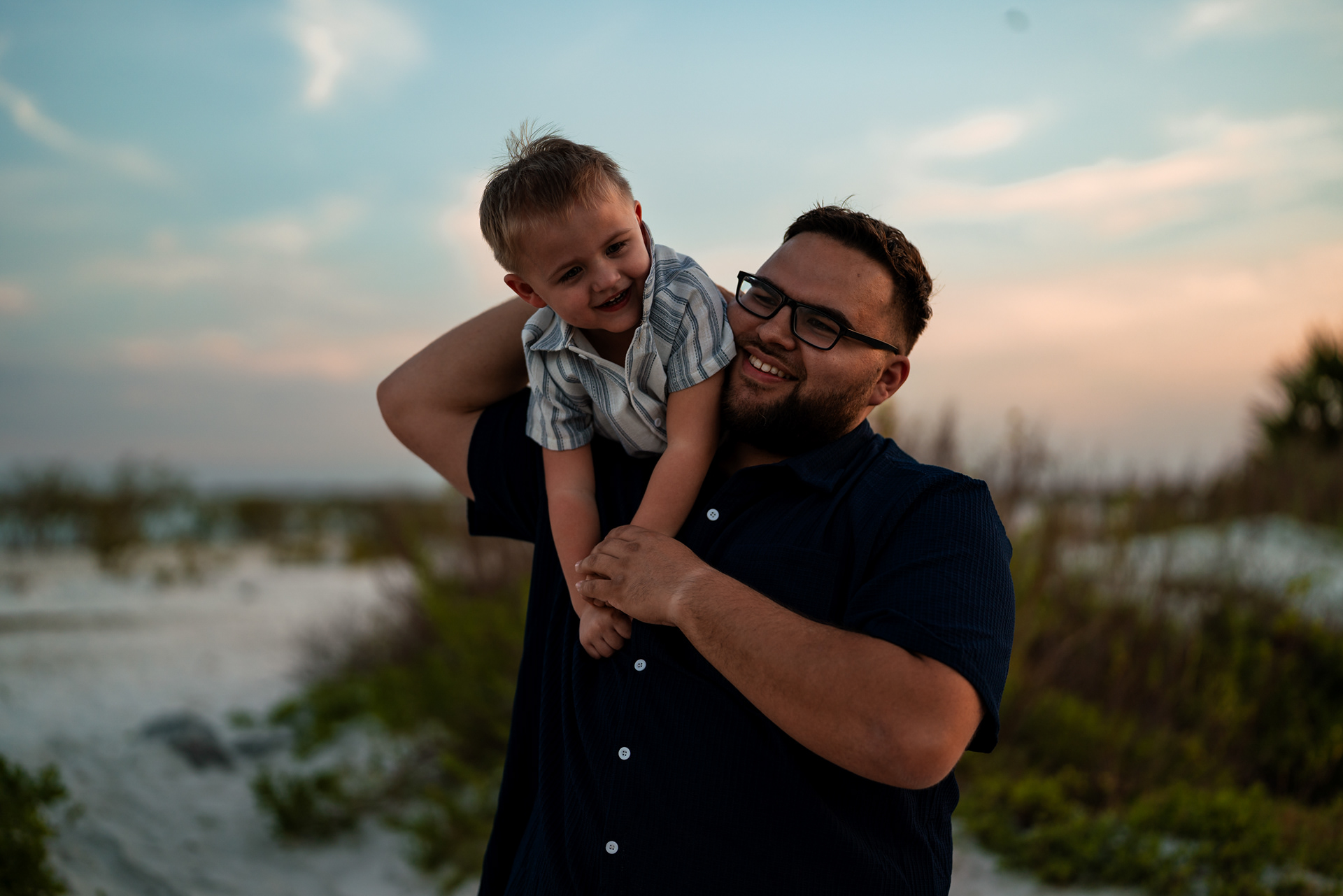 Father laughing with child during candid family photos at Ponce Inlet Beach