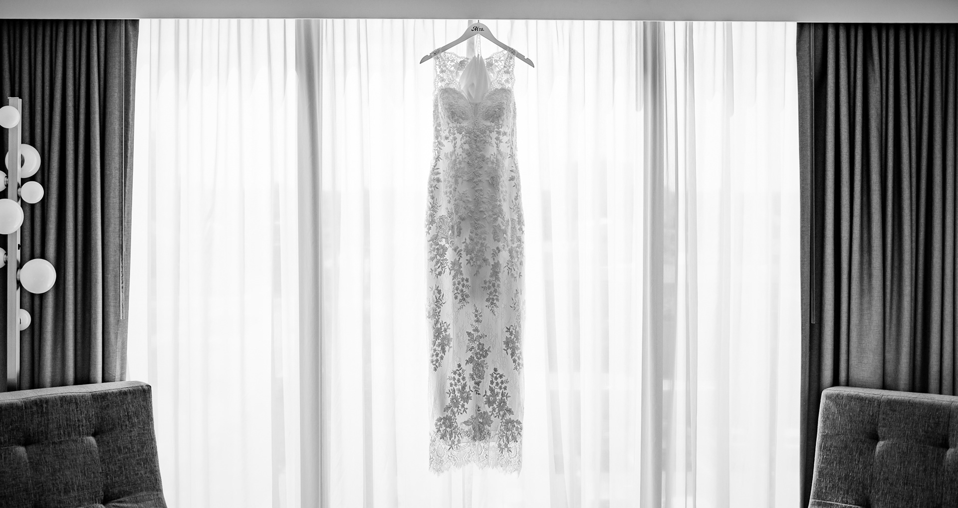 Black and white photo of a wedding dress hanging before a Daytona Beach wedding.