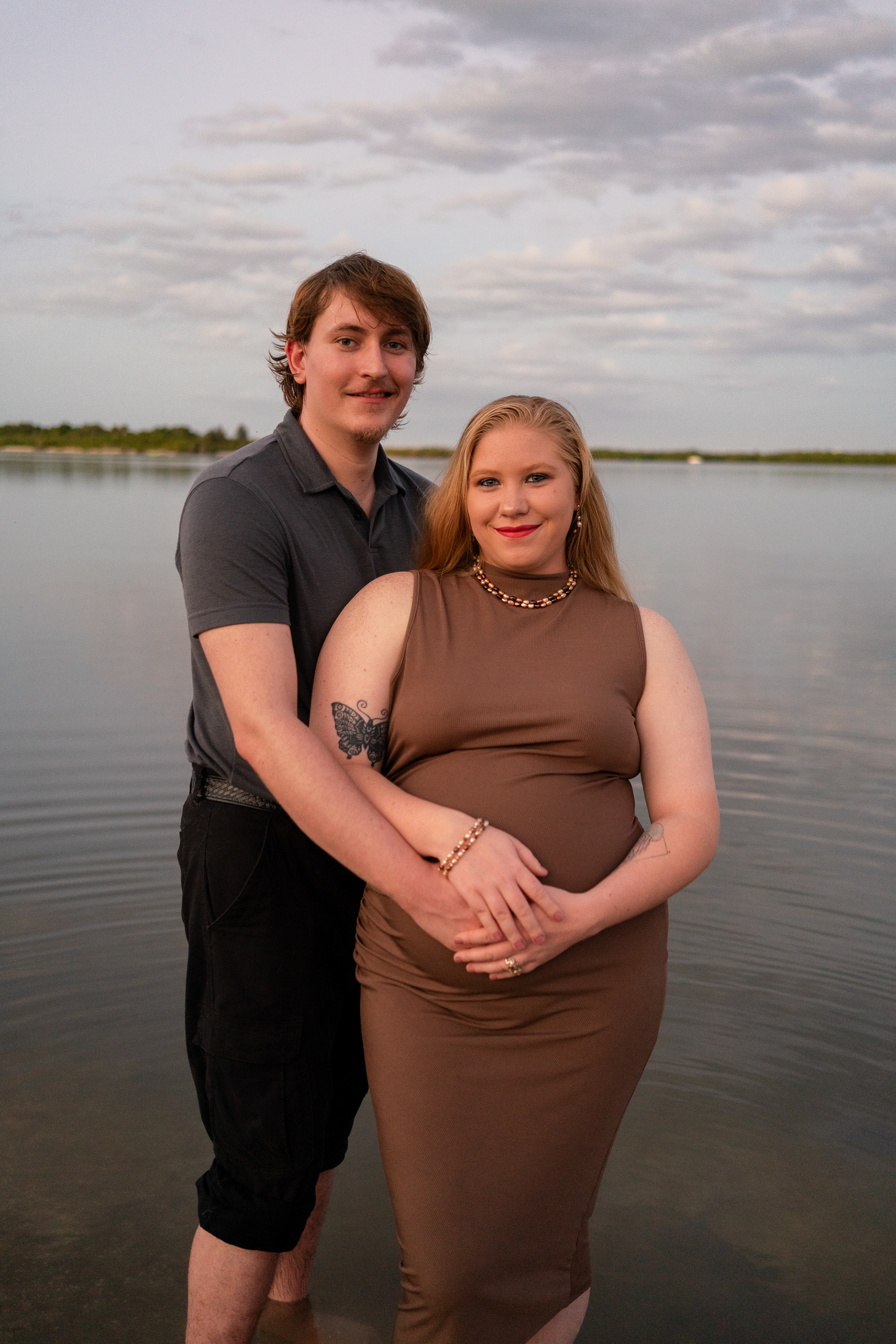 Maternity portrait of pregnant mother standing by the water in Florida
