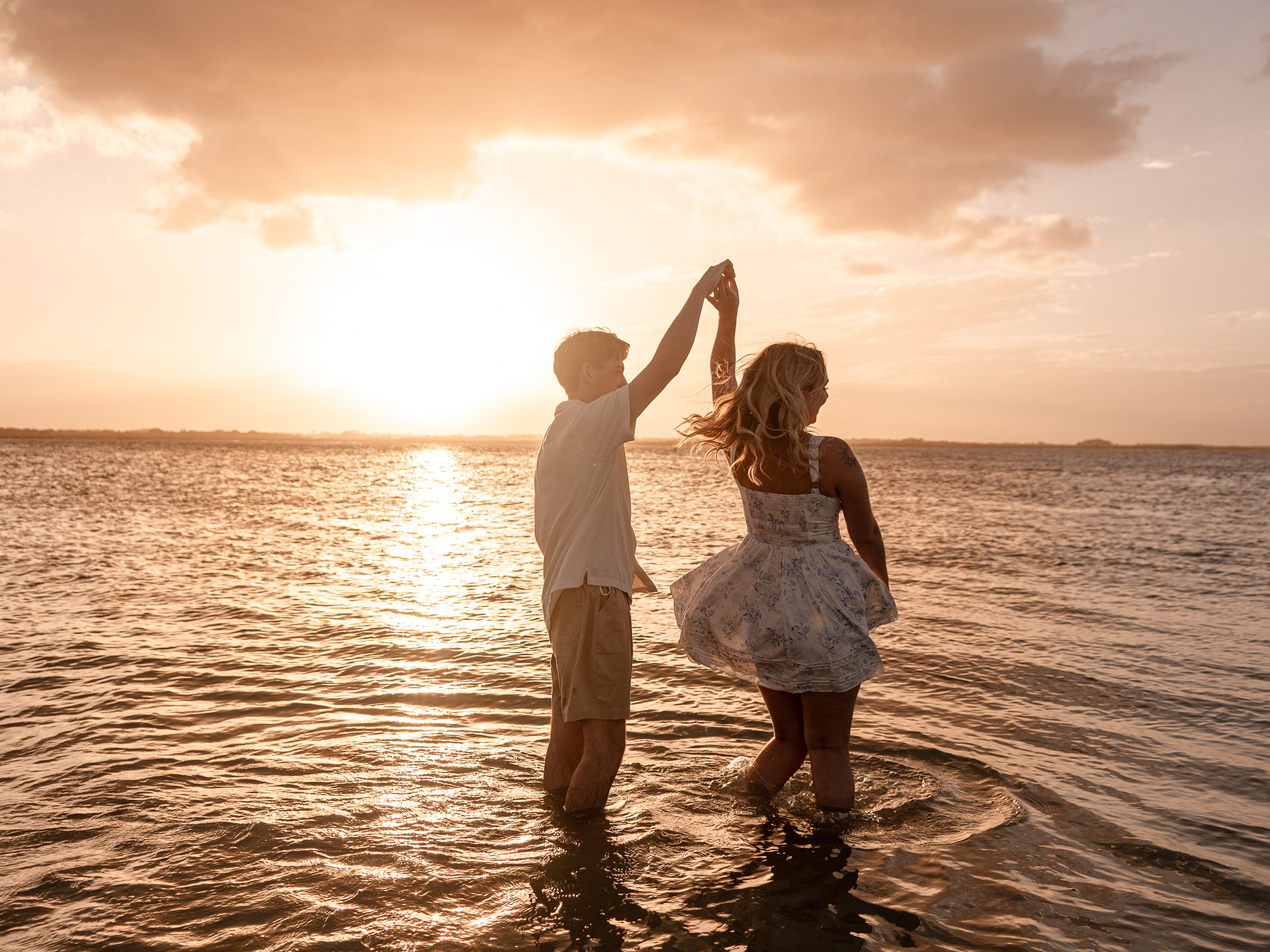 Couple Dancing and spinning in the water during a New Smyrna Beach engagement photo