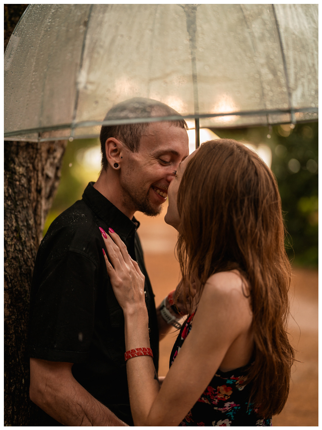 Close portrait of a couple smiling at each other beneath a rain-covered umbrella at Washington Oaks Gardens.