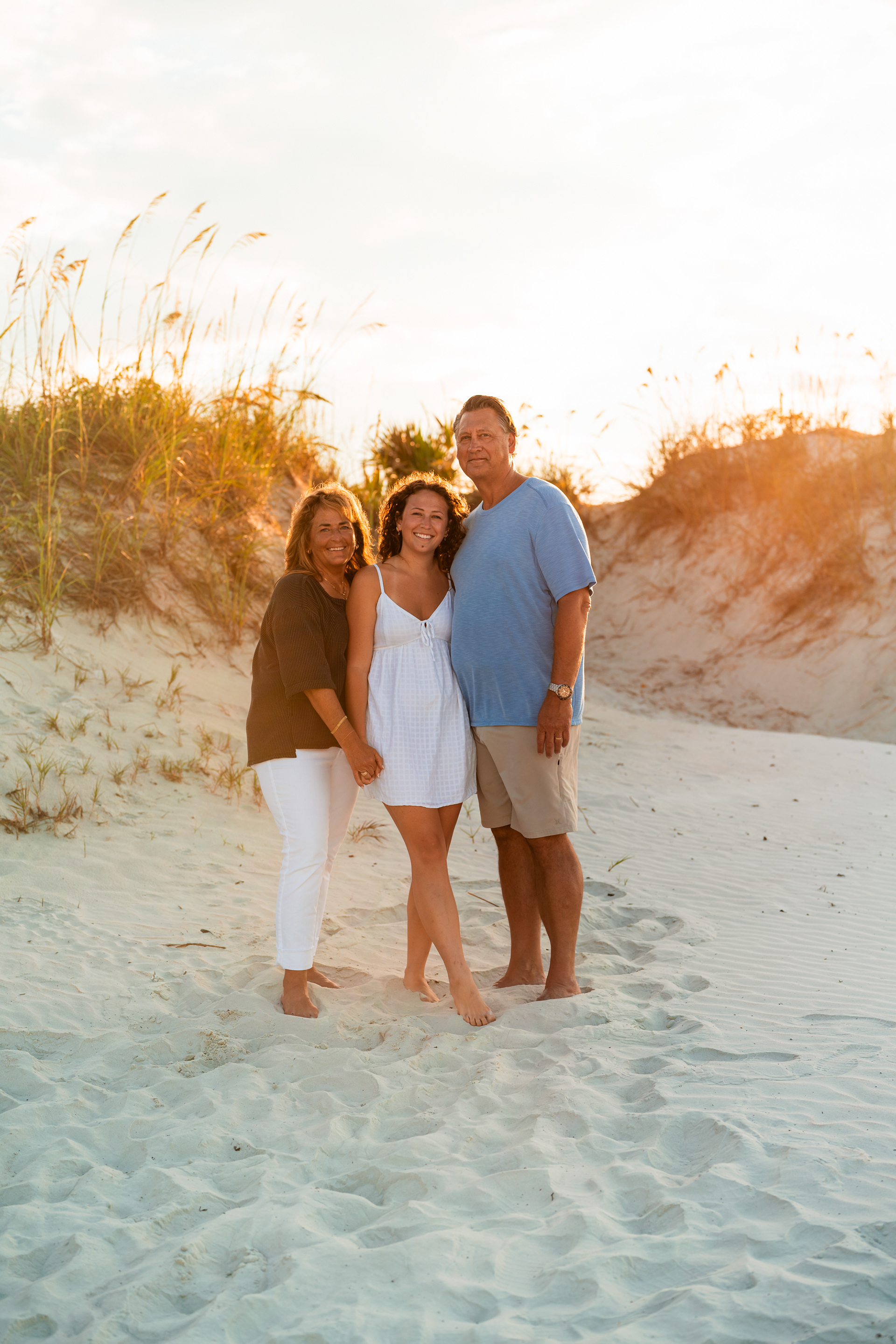 Family standing together in the sand during a Ponce Inlet Jetty Beach photography session.
