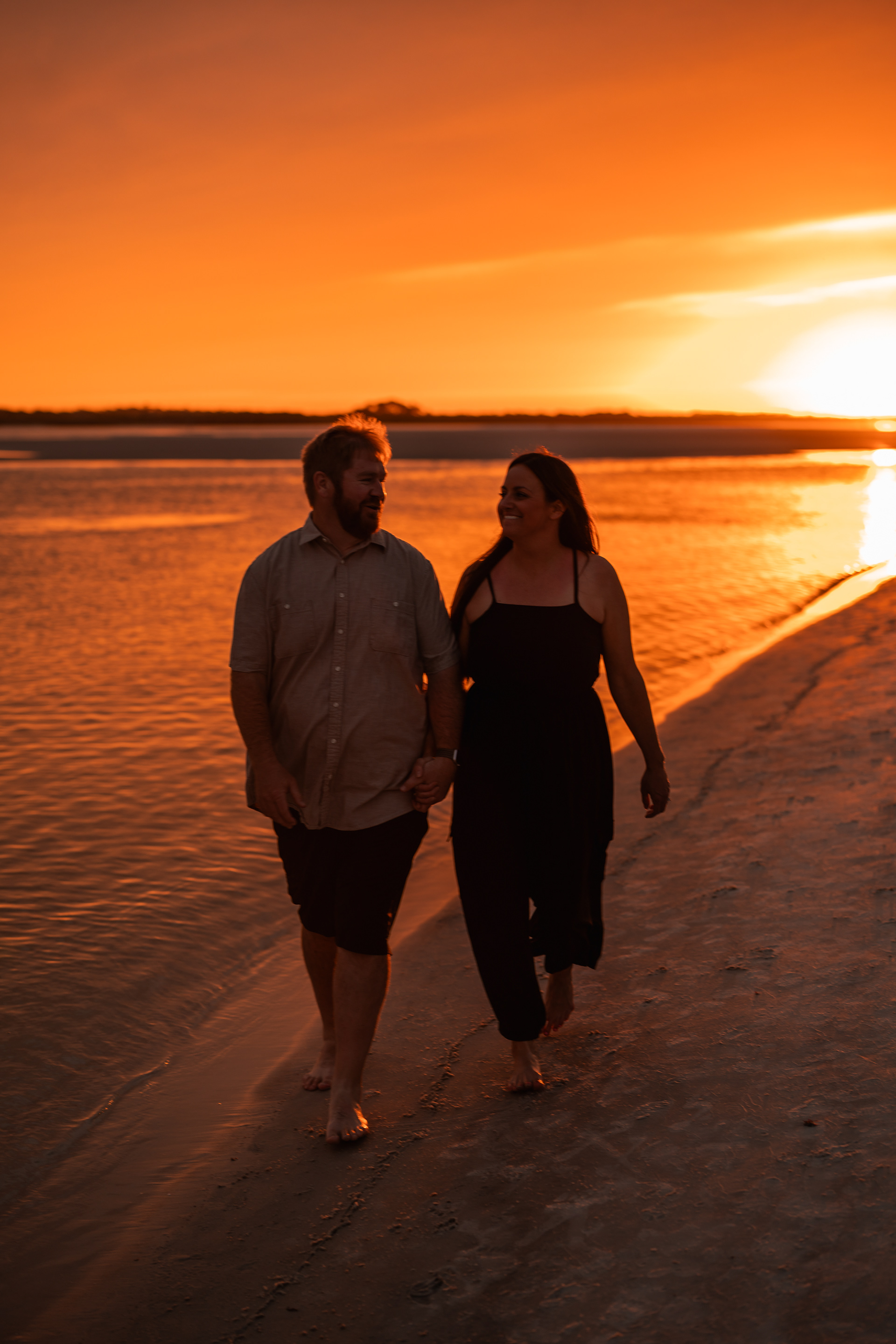 Parents walking together by the water during a sunset beach photography session in Ponce Inlet.