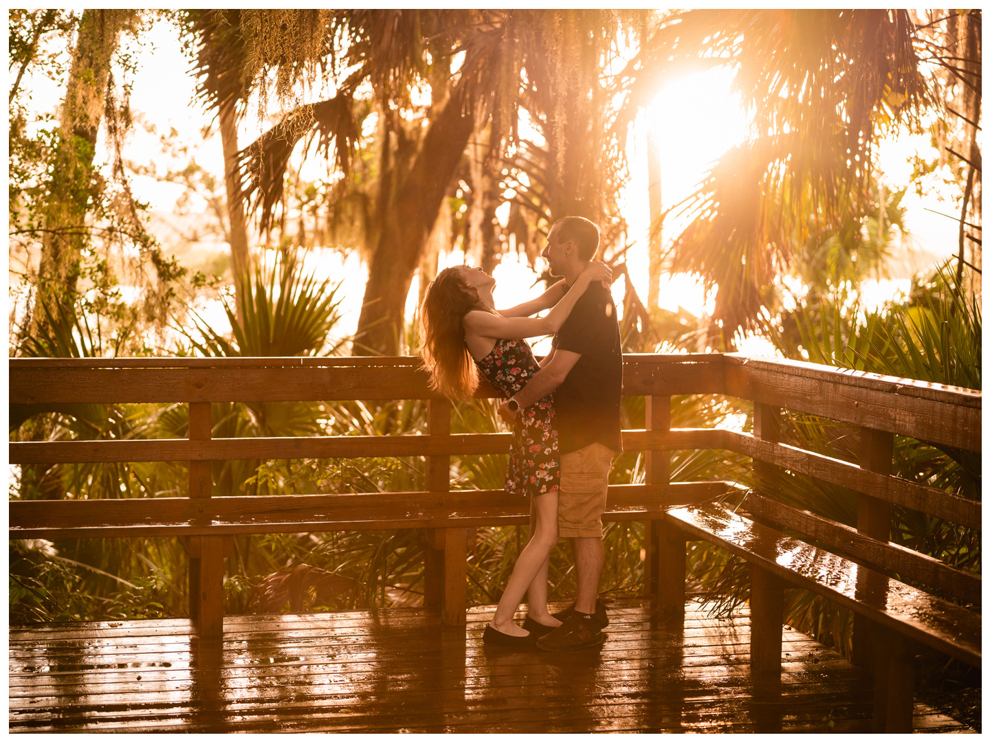 Man dipping his partner on a wet wooden bridge during a Washington Oaks Gardens photo session.