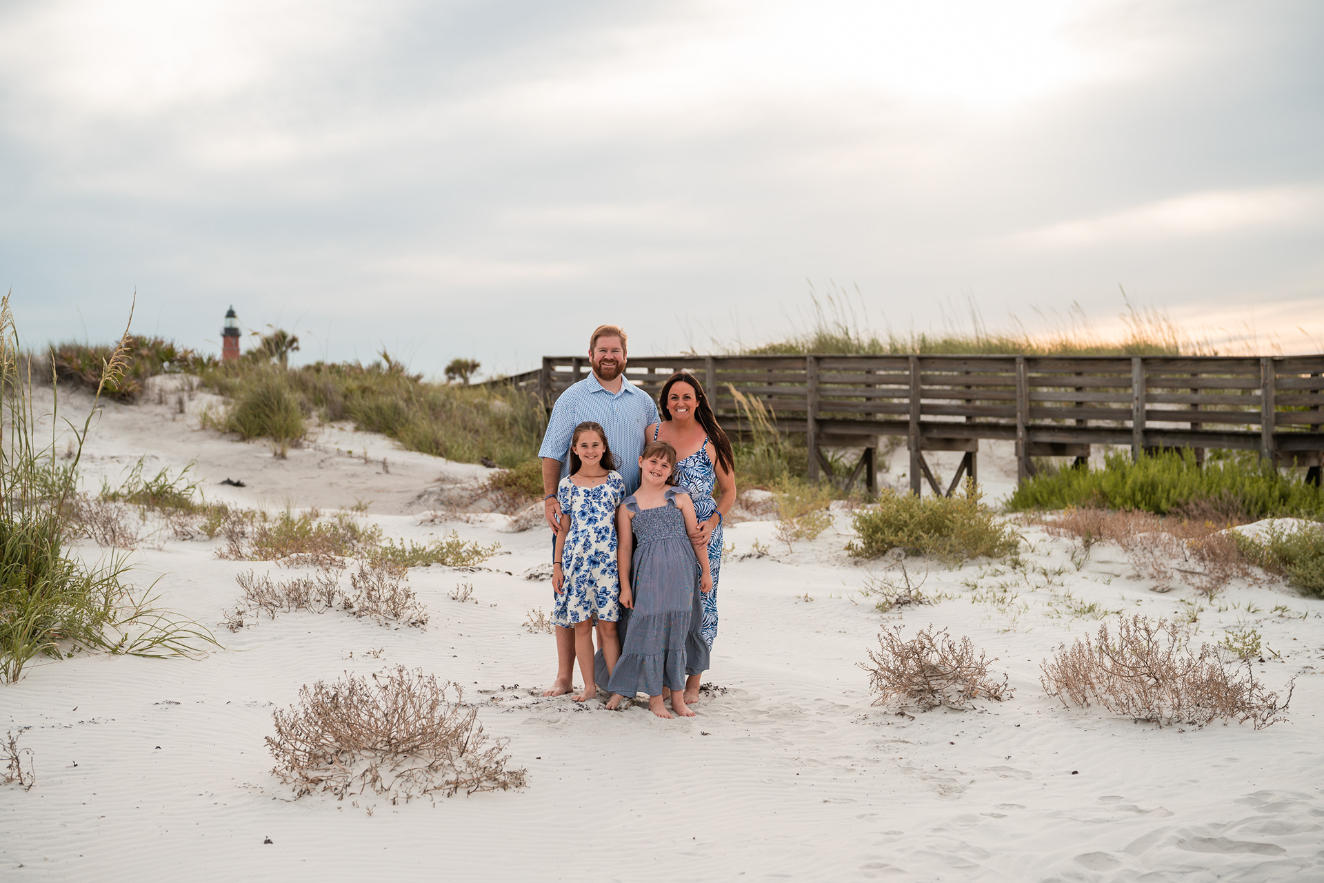 Family standing together in the dunes during a beach photography session in Ponce Inlet.