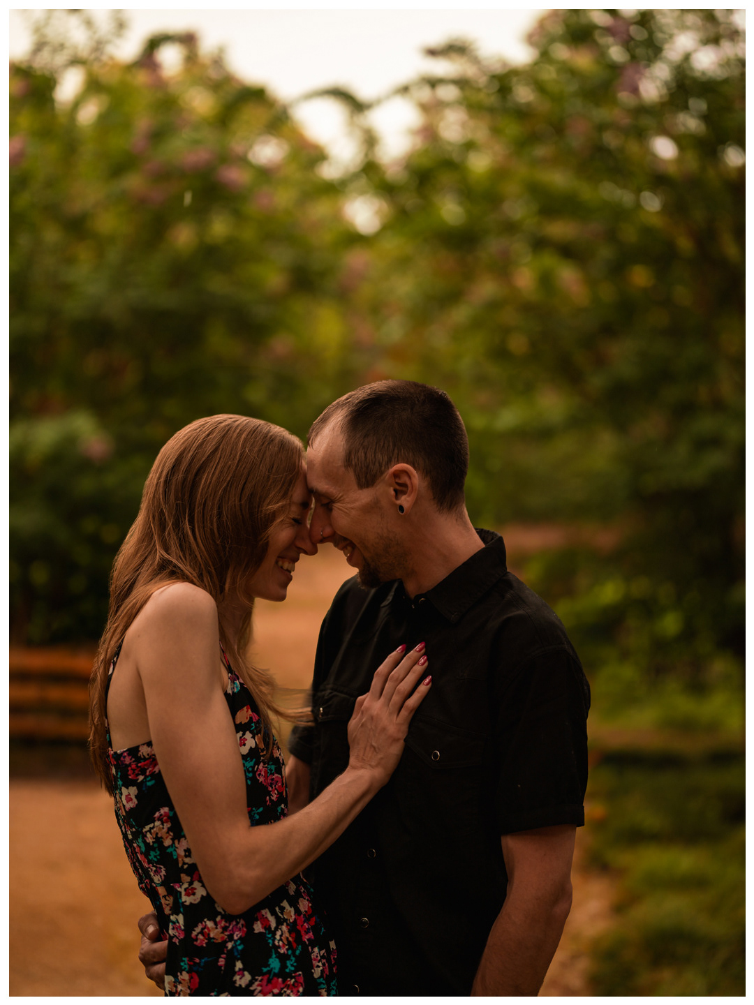 Couple touching foreheads with the woman’s hand on her partner’s chest at Washington Oaks Gardens.
