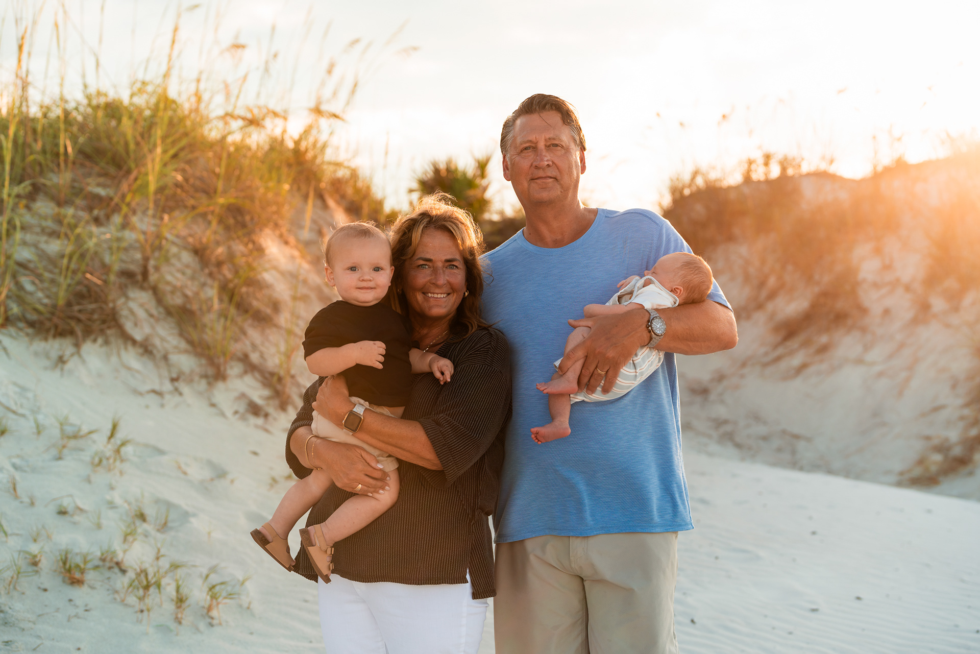 Family members holding two children during a Ponce Inlet Jetty Beach family photography session.