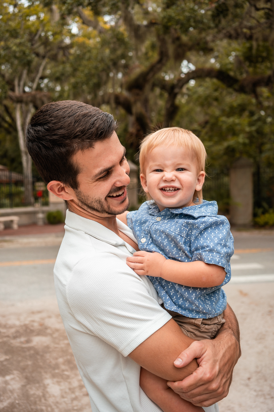 Father holding his youngest son and laughing together during Port Orange family photography session.