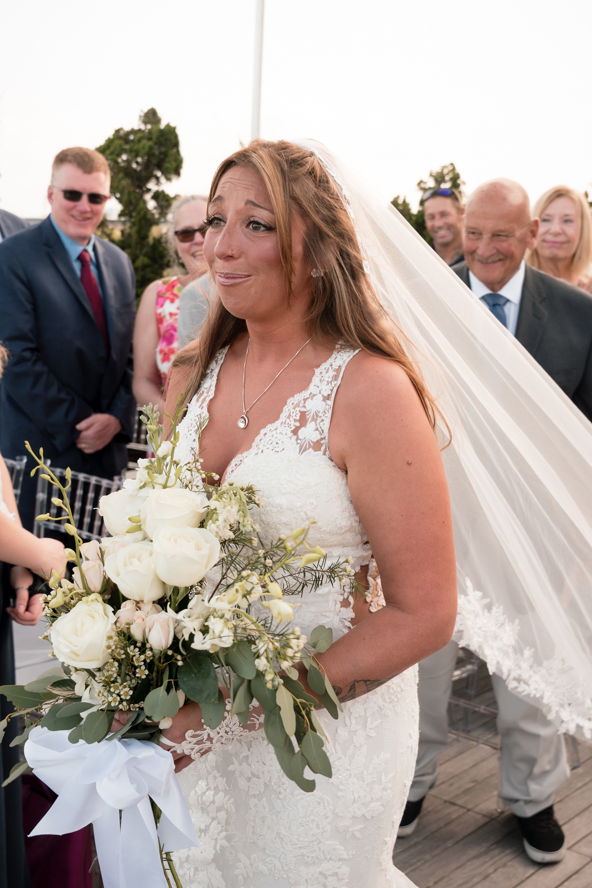 Bride walking down the aisle with her bouquet at Hard Rock Hotel Daytona Beach.