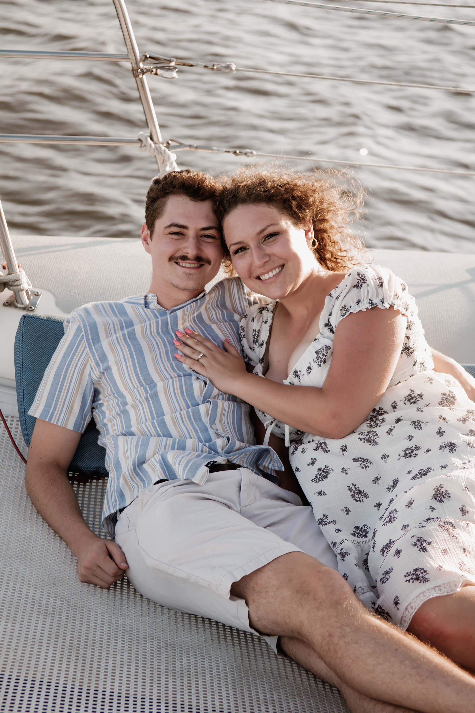 Couple posing together on sailboat during coastal engagement photos in Daytona Beach
