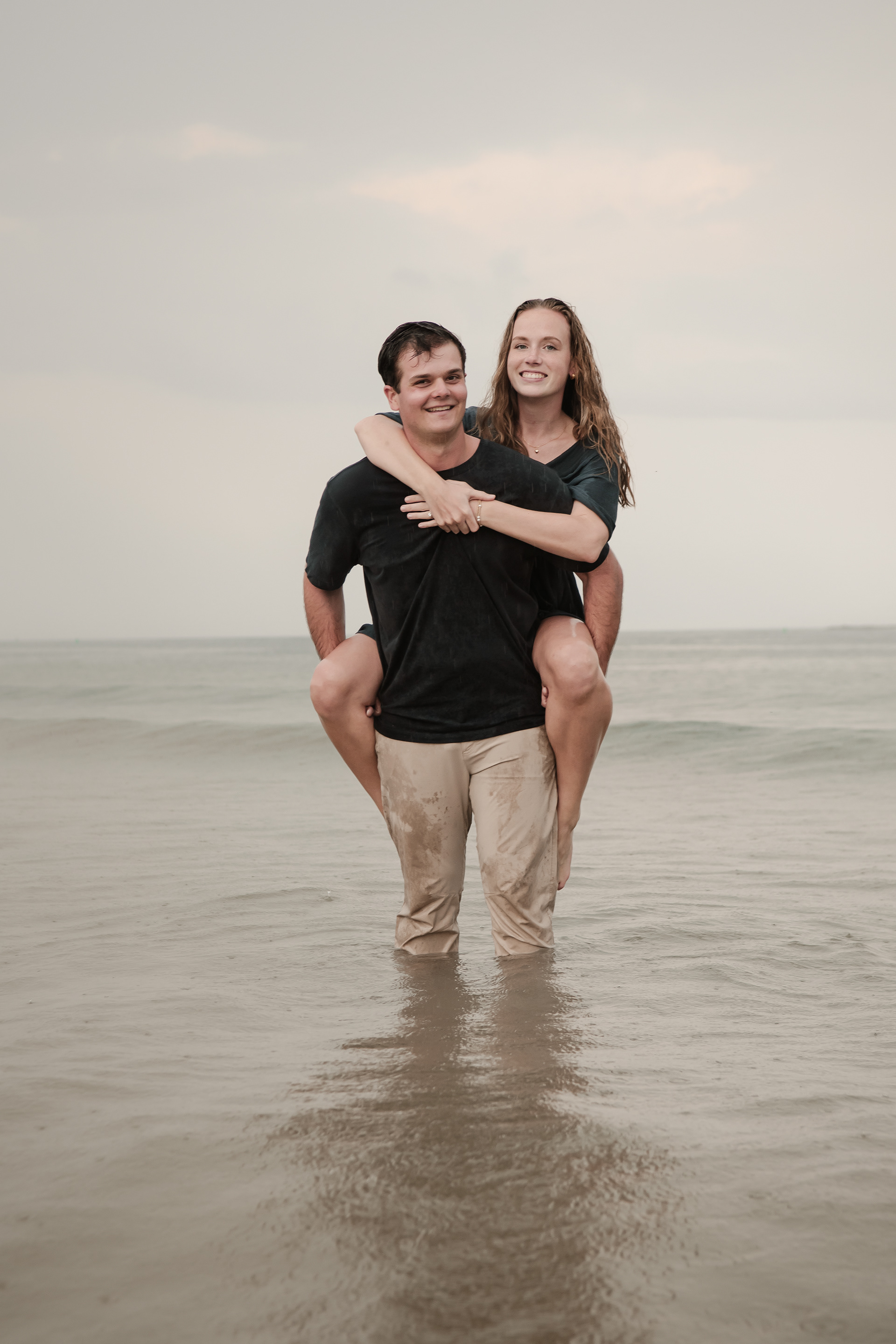 Playful beach engagement photo of couple in the water at Ponce Inlet Florida