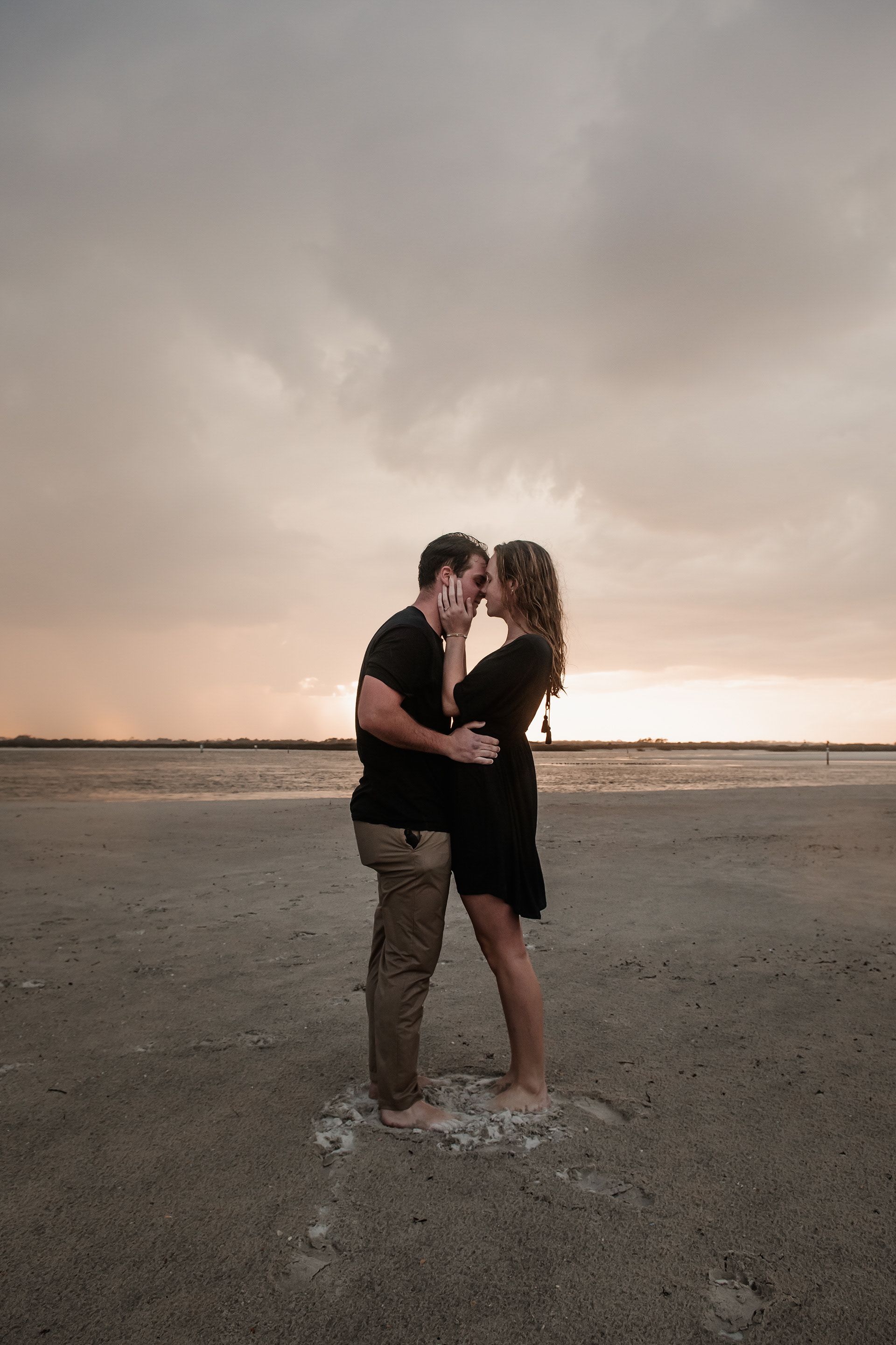Moody Ponce Inlet engagement photo of couple standing together under storm clouds on the beach