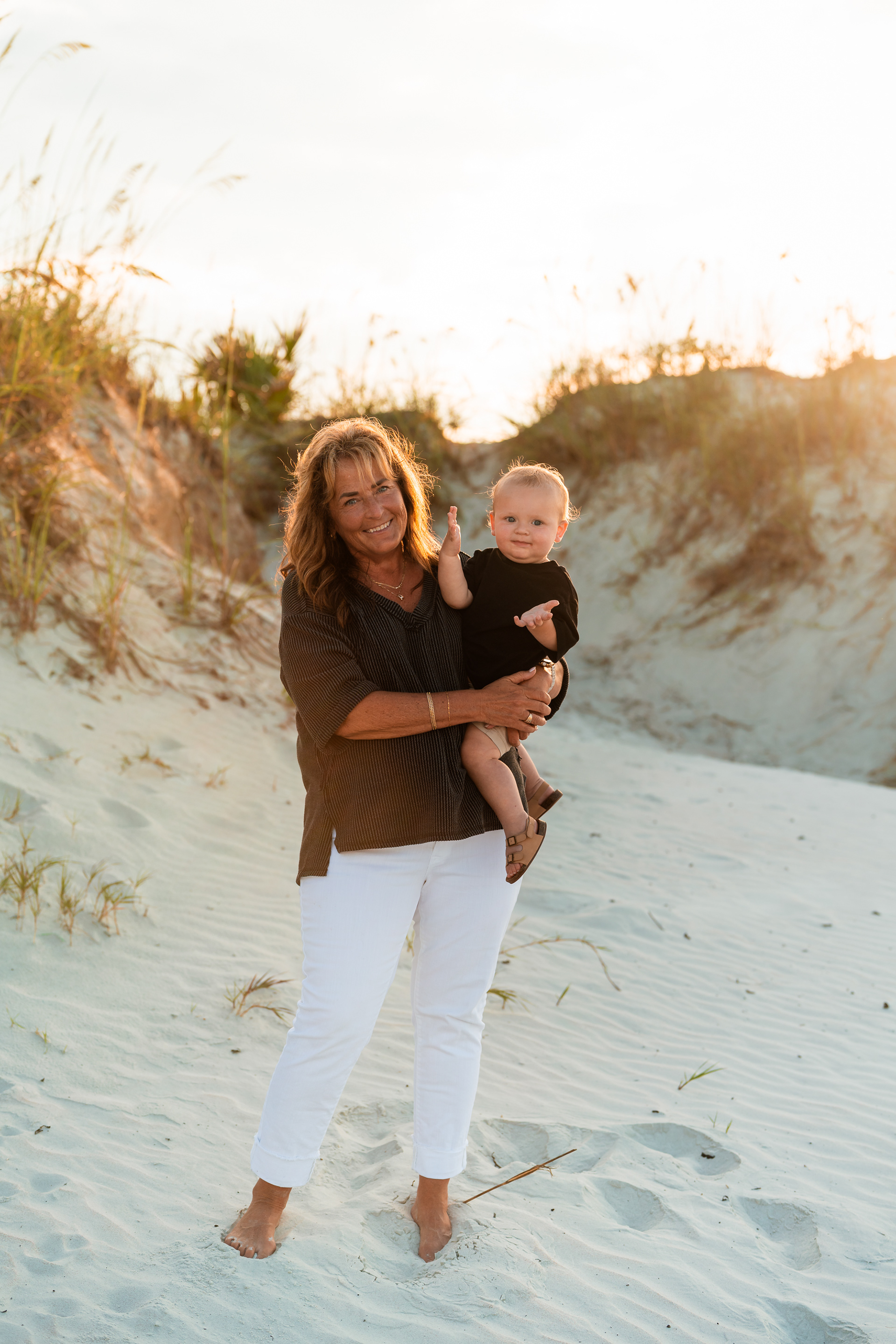Woman smiling while holding a child during a Ponce Inlet Jetty Beach family photography session.