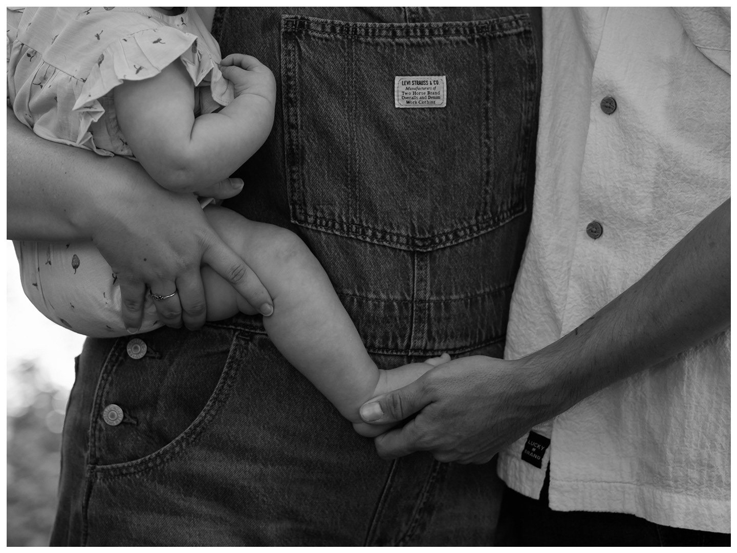 Black and white family photo detail of parents holding baby at Dunlawton Sugar Mill Gardens in Port Orange Florida